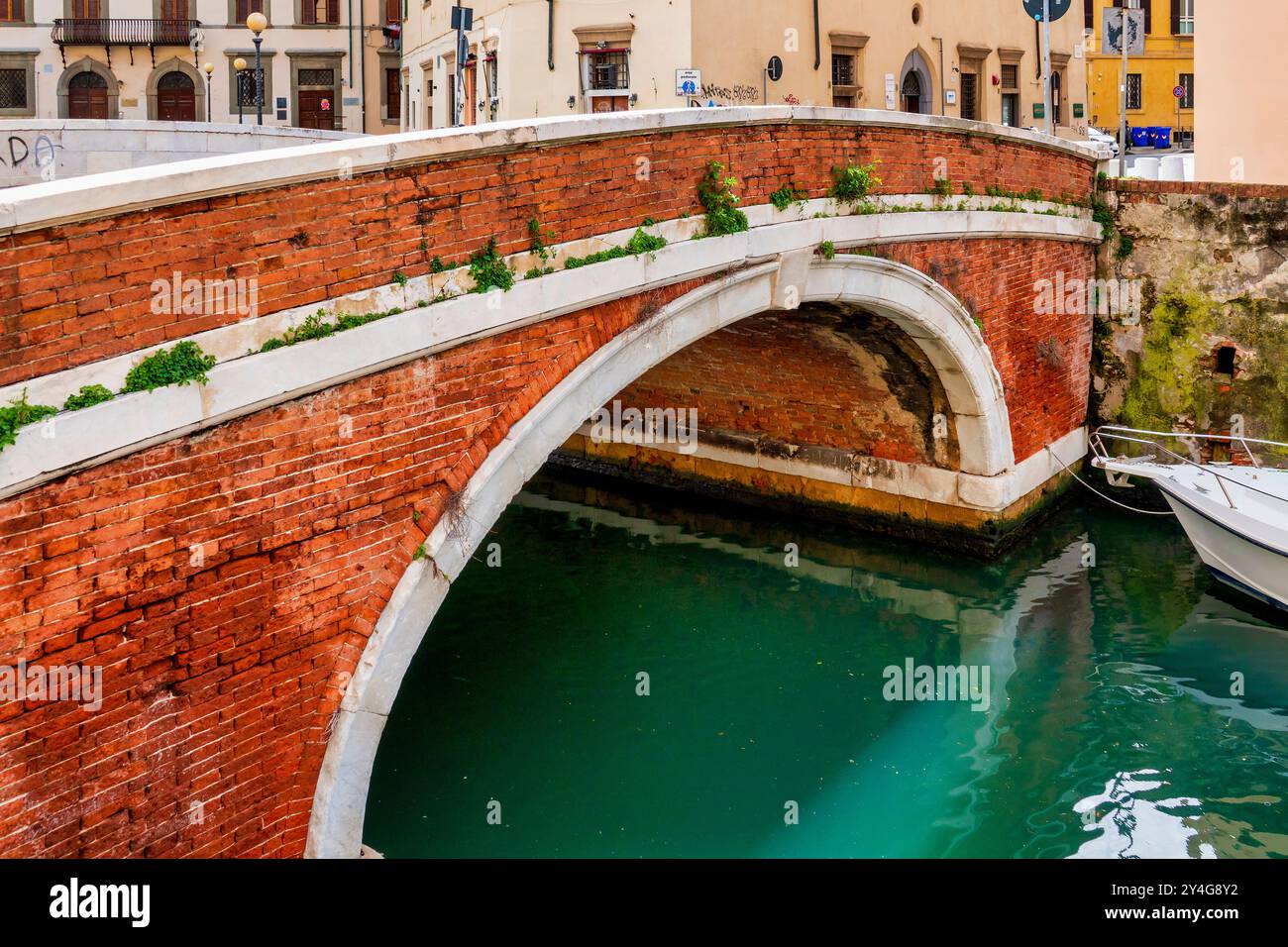 Ponte di Marmo, un pont historique en briques et en pierre à Livourne, en Italie, enjambant un canal dans le vieux port de la ville. Banque D'Images