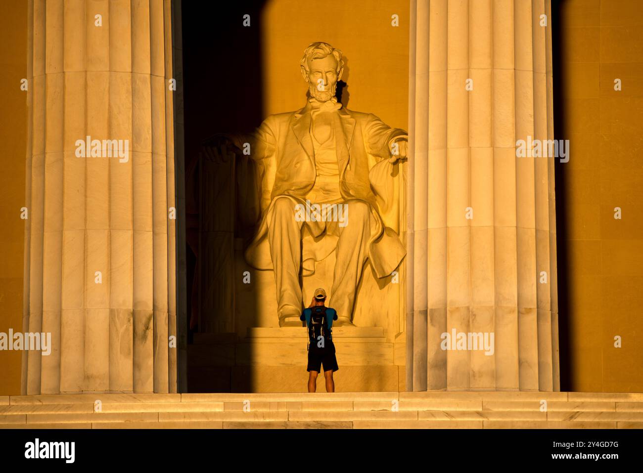 Lincoln Memorial Statue Sunlight Washington DC // WASHINGTON DC — la statue d'Abraham Lincoln à l'intérieur du Lincoln Memorial est illuminée par la lumière naturelle dorée du soleil juste après le lever du soleil. Cet effet lumineux, visible autour de l'équinoxe de printemps et d'automne, renforce la grandeur du monument lorsque le soleil brille à travers l'entrée est. Le Lincoln Memorial, situé sur le National Mall, est l'un des monuments les plus emblématiques des États-Unis. NB : la couleur et l'éclairage sont naturels. Banque D'Images