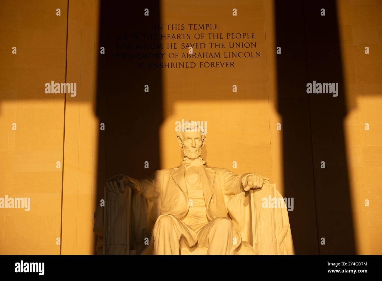 Lincoln Memorial Statue Sunlight Washington DC // WASHINGTON DC — la statue d'Abraham Lincoln à l'intérieur du Lincoln Memorial est illuminée par la lumière naturelle dorée du soleil juste après le lever du soleil. Cet effet lumineux, visible autour de l'équinoxe de printemps et d'automne, renforce la grandeur du monument lorsque le soleil brille à travers l'entrée est. Le Lincoln Memorial, situé sur le National Mall, est l'un des monuments les plus emblématiques des États-Unis. NB : la couleur et l'éclairage sont naturels. Banque D'Images