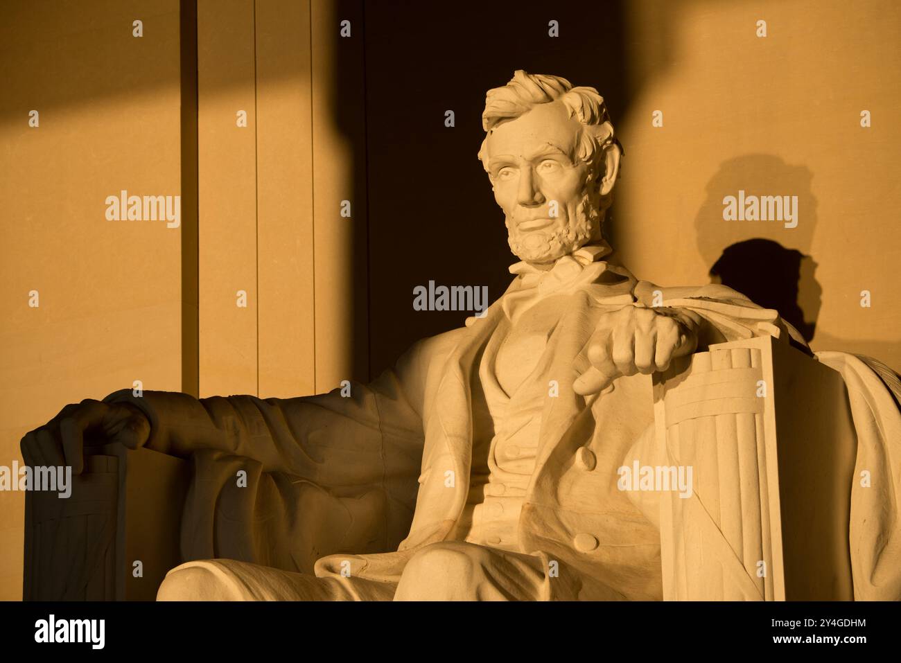 Lincoln Memorial Statue Sunlight Washington DC // WASHINGTON DC — la statue d'Abraham Lincoln à l'intérieur du Lincoln Memorial est illuminée par la lumière naturelle dorée du soleil juste après le lever du soleil. Cet effet lumineux, visible autour de l'équinoxe de printemps et d'automne, renforce la grandeur du monument lorsque le soleil brille à travers l'entrée est. Le Lincoln Memorial, situé sur le National Mall, est l'un des monuments les plus emblématiques des États-Unis. NB : la couleur et l'éclairage sont naturels. Banque D'Images