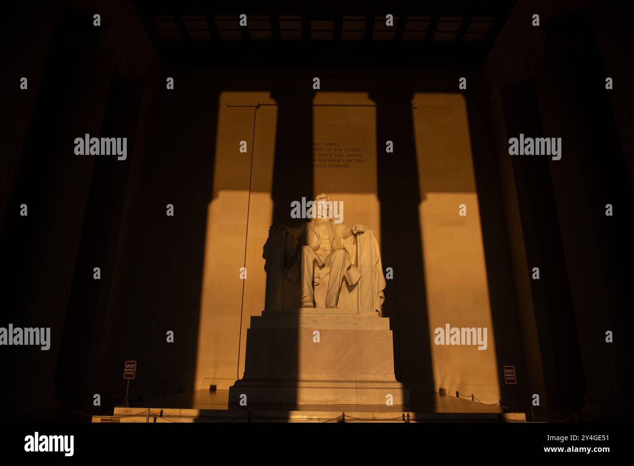 Lincoln Memorial Abraham Lincoln Statue Washington DC // WASHINGTON DC — la statue d'Abraham Lincoln à l'intérieur du Lincoln Memorial est illuminée par la lumière naturelle dorée du soleil juste après le lever du soleil. Cet effet lumineux, visible autour de l'équinoxe de printemps et d'automne, renforce la grandeur du monument lorsque le soleil brille à travers l'entrée est. Le Lincoln Memorial, situé sur le National Mall, est l'un des monuments les plus emblématiques des États-Unis. NB : la couleur et l'éclairage sont naturels. Banque D'Images