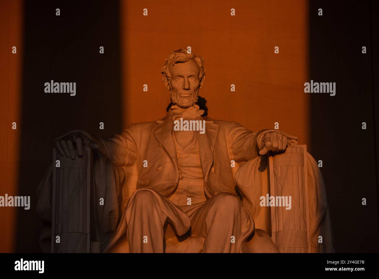 Lincoln Memorial Statue Sunlight Washington DC // WASHINGTON DC — la statue d'Abraham Lincoln à l'intérieur du Lincoln Memorial est illuminée par la lumière naturelle dorée du soleil juste après le lever du soleil. Cet effet lumineux, visible autour de l'équinoxe de printemps et d'automne, renforce la grandeur du monument lorsque le soleil brille à travers l'entrée est. Le Lincoln Memorial, situé sur le National Mall, est l'un des monuments les plus emblématiques des États-Unis. NB : la couleur et l'éclairage sont naturels. Banque D'Images