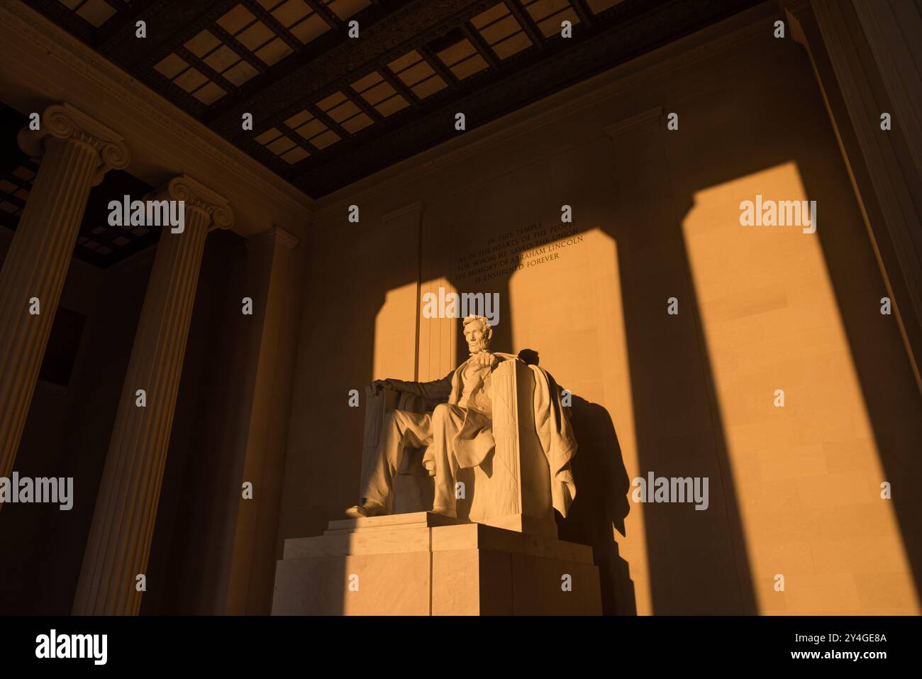 Lincoln Memorial Abraham Lincoln Statue Washington DC // WASHINGTON DC — la statue d'Abraham Lincoln à l'intérieur du Lincoln Memorial est illuminée par la lumière naturelle dorée du soleil juste après le lever du soleil. Cet effet lumineux, visible autour de l'équinoxe de printemps et d'automne, renforce la grandeur du monument lorsque le soleil brille à travers l'entrée est. Le Lincoln Memorial, situé sur le National Mall, est l'un des monuments les plus emblématiques des États-Unis. NB : la couleur et l'éclairage sont naturels. Banque D'Images
