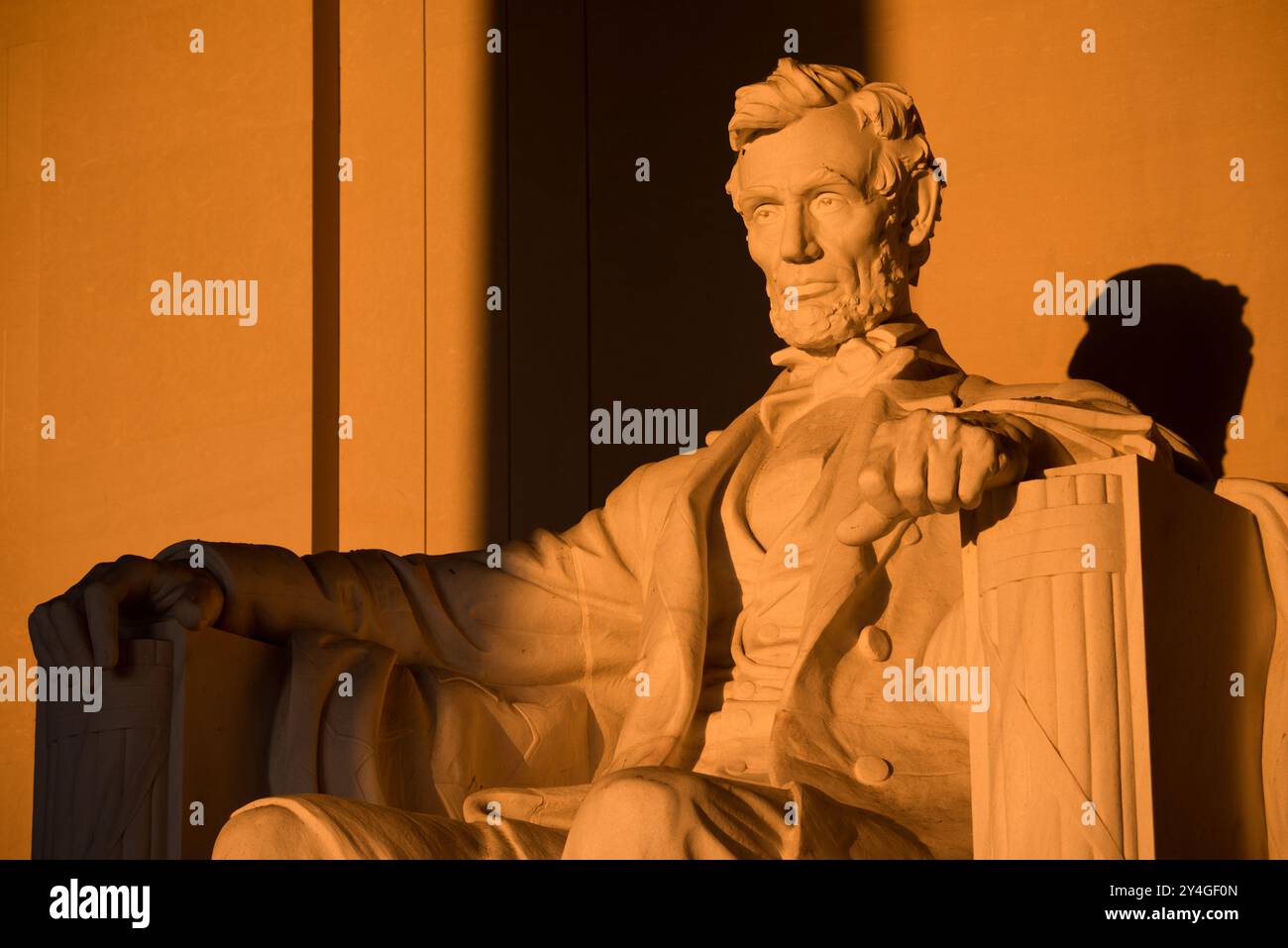 Lincoln Memorial Abraham Lincoln Statue Washington DC // WASHINGTON DC — la statue d'Abraham Lincoln à l'intérieur du Lincoln Memorial est illuminée par la lumière naturelle dorée du soleil juste après le lever du soleil. Cet effet lumineux, visible autour de l'équinoxe de printemps et d'automne, renforce la grandeur du monument lorsque le soleil brille à travers l'entrée est. Le Lincoln Memorial, situé sur le National Mall, est l'un des monuments les plus emblématiques des États-Unis. NB : la couleur et l'éclairage sont naturels. Banque D'Images