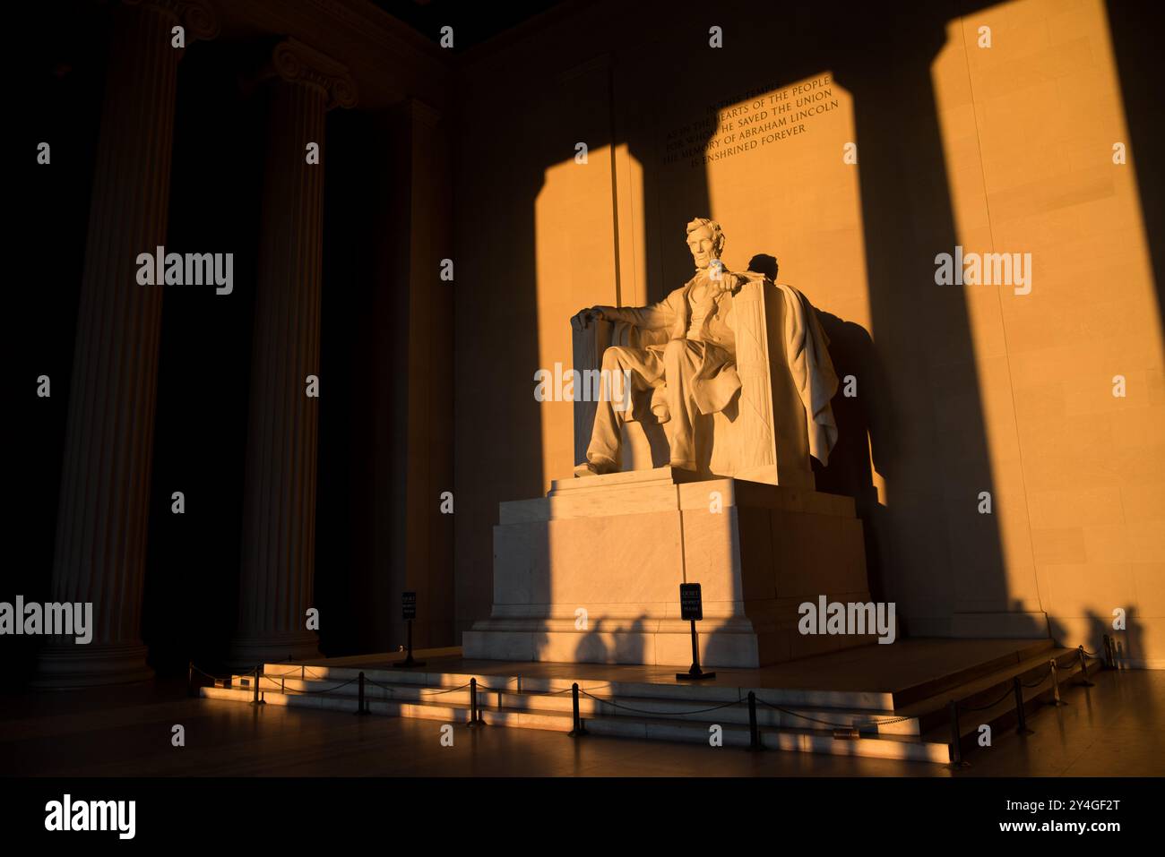Lincoln Memorial Abraham Lincoln Statue Washington DC // WASHINGTON DC — la statue d'Abraham Lincoln à l'intérieur du Lincoln Memorial est illuminée par la lumière naturelle dorée du soleil juste après le lever du soleil. Cet effet lumineux, visible autour de l'équinoxe de printemps et d'automne, renforce la grandeur du monument lorsque le soleil brille à travers l'entrée est. Le Lincoln Memorial, situé sur le National Mall, est l'un des monuments les plus emblématiques des États-Unis. NB : la couleur et l'éclairage sont naturels. Banque D'Images