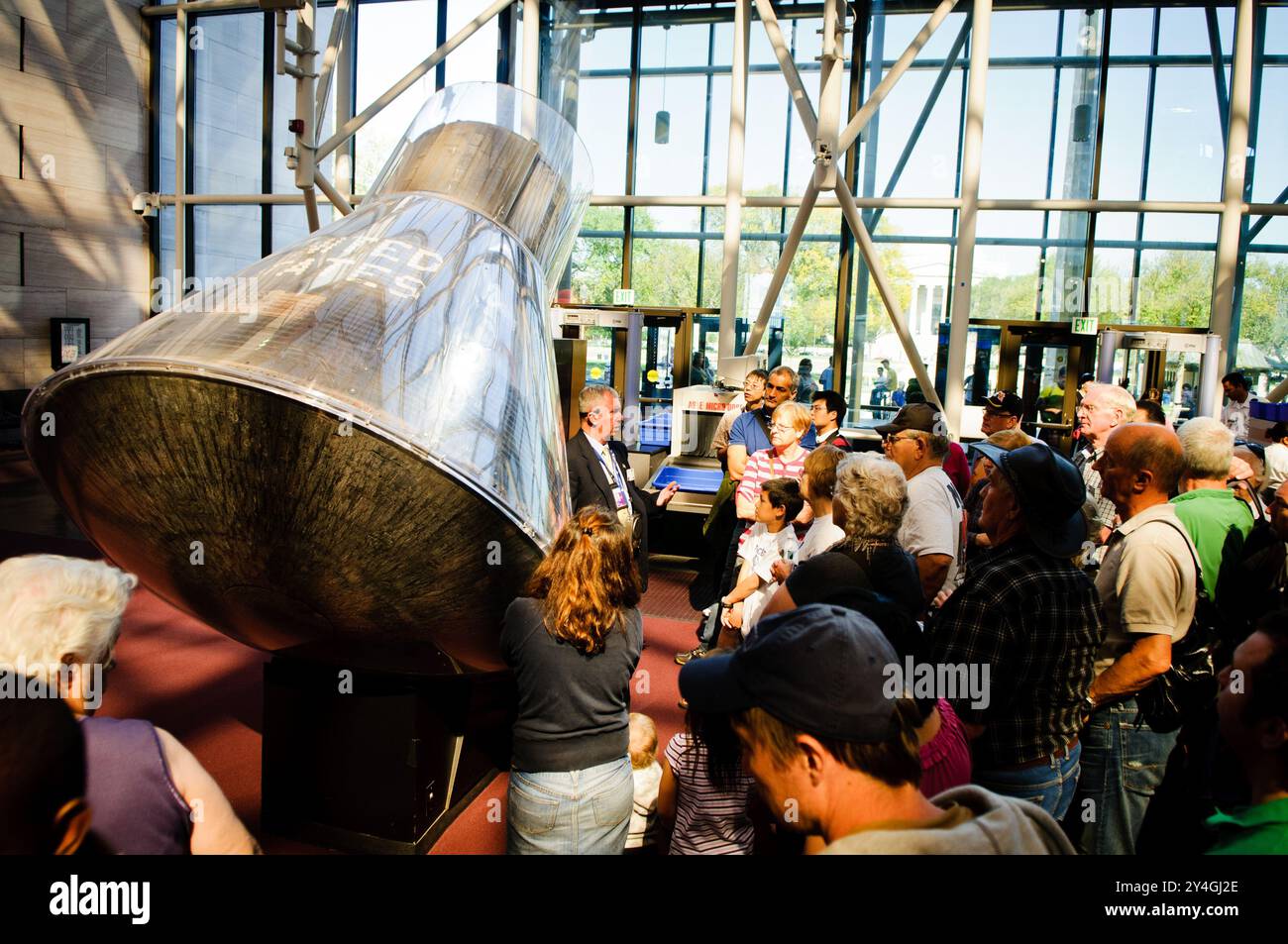 Musée national de l'air et de l'espace Mercury 7 capsule Washington DC // WASHINGTON DC — les visiteurs du musée national de l'air et de l'espace écoutent un guide expliquer le véhicule de rentrée Mercury 7, la capsule qui a transporté John Glenn, le premier américain à orbiter autour de la Terre, en toute sécurité vers l'espace et retour en 1962. Ce vaisseau spatial historique est une pièce maîtresse des expositions d'exploration spatiale du musée. Banque D'Images