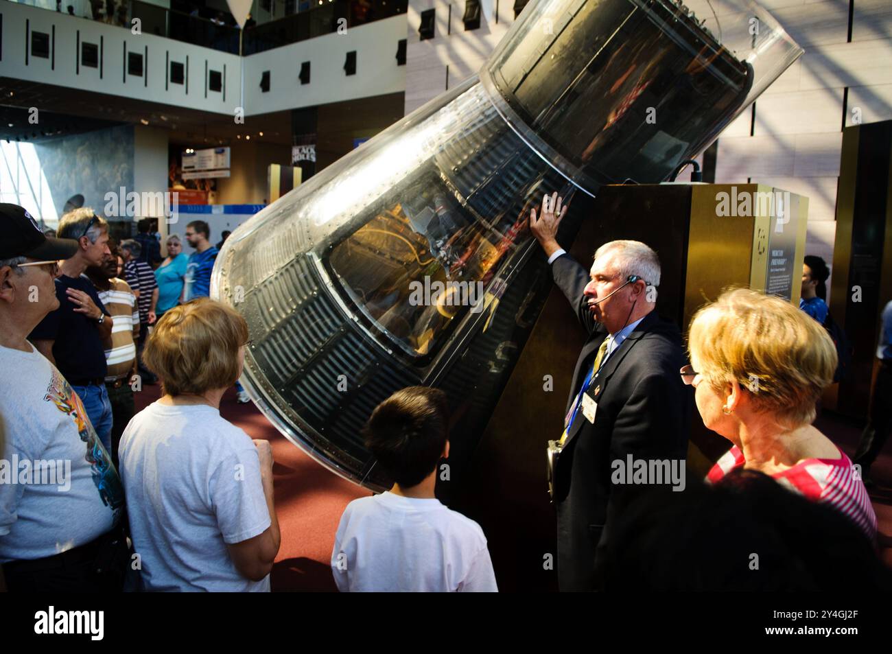 Musée national de l'air et de l'espace Mercury 7 capsule Washington DC // WASHINGTON DC — les visiteurs du musée national de l'air et de l'espace écoutent un guide expliquer le véhicule de rentrée Mercury 7, la capsule qui a transporté John Glenn, le premier américain à orbiter autour de la Terre, en toute sécurité vers l'espace et retour en 1962. Ce vaisseau spatial historique est une pièce maîtresse des expositions d'exploration spatiale du musée. Banque D'Images