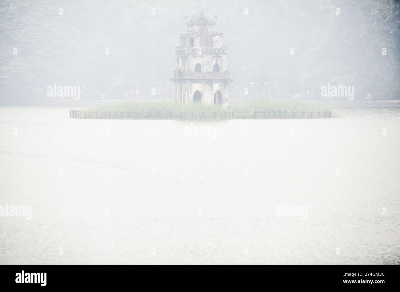 Tour de tortue Thap Rua Hoan Kiem Lac Hanoi Vietnam // HANOI, Vietnam — la Tour de tortue historique (Thap Rua) émerge à travers le brouillard matinal sur le lac Hoan Kiem. La tour du XIXe siècle, construite sur une petite île au centre du lac, commémore la légendaire tortue dorée du folklore vietnamien. Cette structure emblématique est l'un des monuments les plus reconnaissables de Hanoi dans le quartier historique de la ville. Banque D'Images