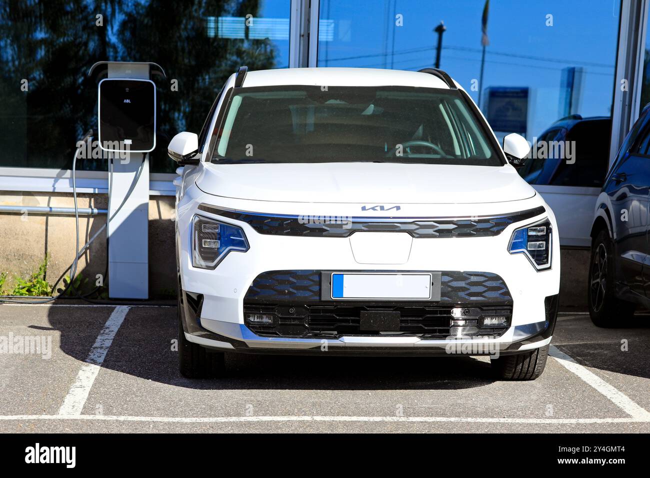 Voiture crossover électrique à batterie Kia Niro (II) blanche 2024 garée à côté du chargeur de batterie chez le concessionnaire. Salo, Finlande. 23 juin 2024. Banque D'Images