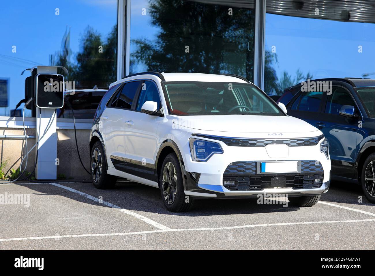 Voiture crossover électrique à batterie Kia Niro (II) blanche 2024 garée à côté du chargeur de batterie chez le concessionnaire. Salo, Finlande. 23 juin 2024. Banque D'Images