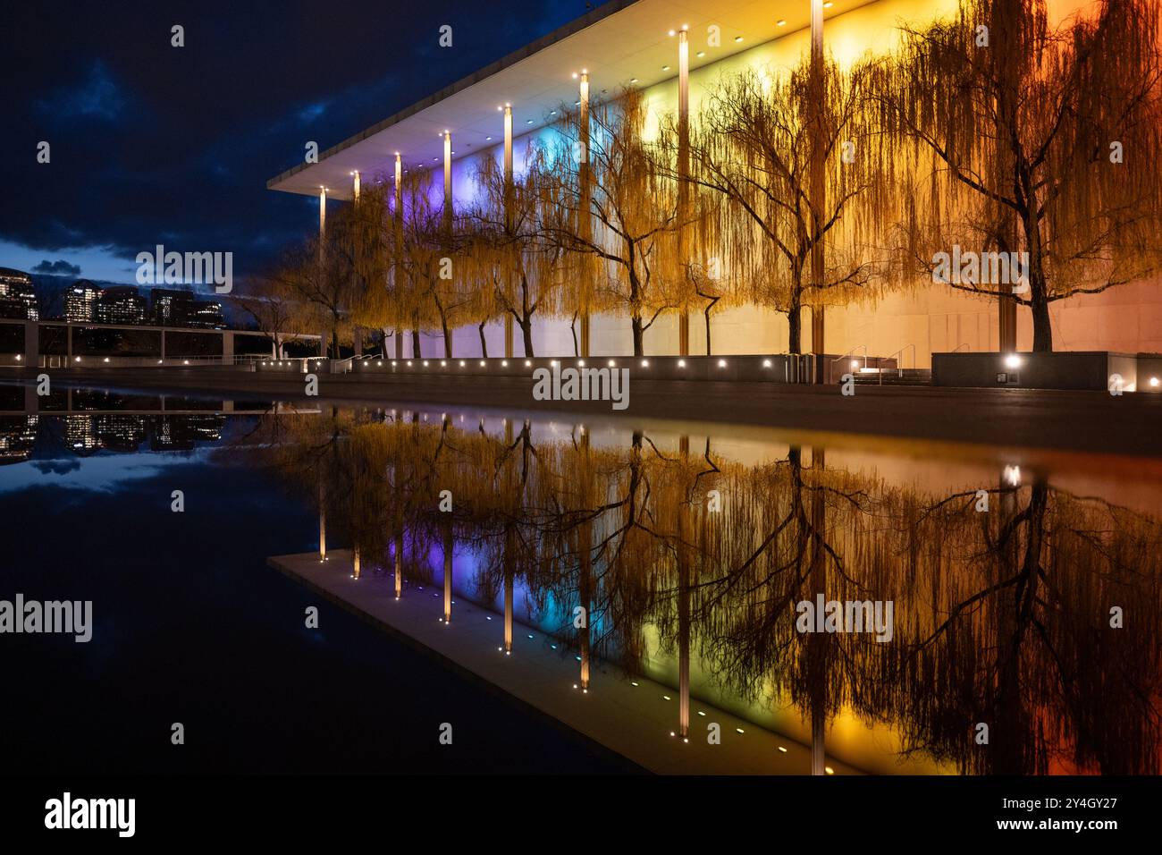 Kennedy Center illuminé la nuit Washington DC // WASHINGTON DC — le John F. Kennedy Center for the Performing Arts est illuminé la nuit avec des lumières colorées pour le Kennedy Center Honors, son reflet capturé dans une flaque après une pluie récente. Le monument culturel emblématique sur le fleuve Potomac met en valeur sa beauté architecturale et son importance en tant que lieu national pour les art. Banque D'Images Kennedy Center illuminé la nuit Washington DC // WASHINGTON DC — le John F. Kennedy Center for the Performing Arts est illuminé la nuit avec des lumières colorées pour le Kennedy Center Honors, son reflet capturé dans une flaque après une pluie récente. Le monument culturel emblématique sur le fleuve Potomac met en valeur sa beauté architecturale et son importance en tant que lieu national pour les art. Banque D'Images