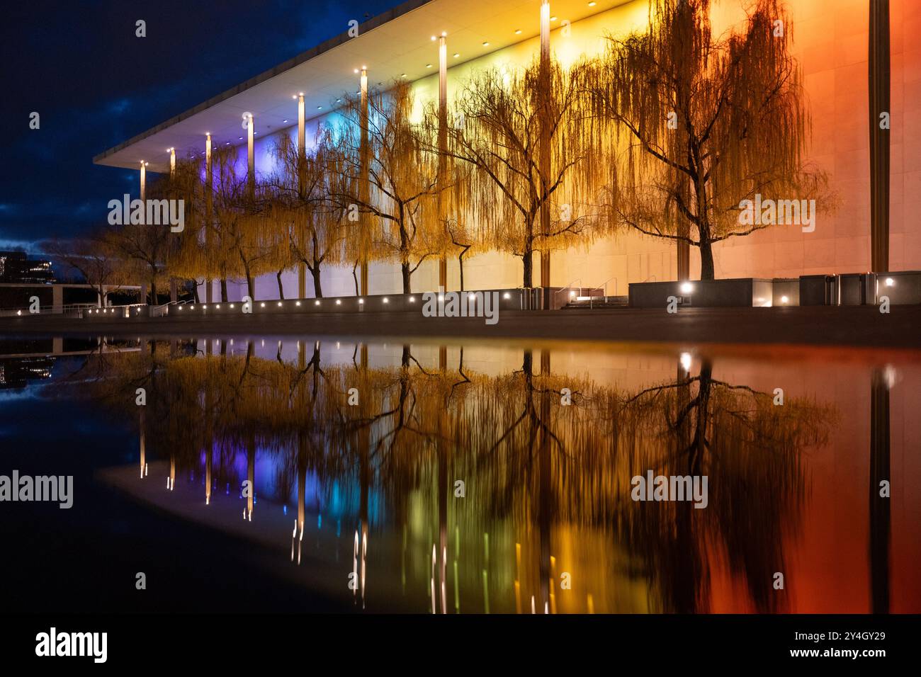 Kennedy Center illuminé la nuit Washington DC // WASHINGTON DC — le John F. Kennedy Center for the Performing Arts est illuminé la nuit avec des lumières colorées pour le Kennedy Center Honors, son reflet capturé dans une flaque après une pluie récente. Le monument culturel emblématique sur le fleuve Potomac met en valeur sa beauté architecturale et son importance en tant que lieu national pour les art. Banque D'Images Kennedy Center illuminé la nuit Washington DC // WASHINGTON DC — le John F. Kennedy Center for the Performing Arts est illuminé la nuit avec des lumières colorées pour le Kennedy Center Honors, son reflet capturé dans une flaque après une pluie récente. Le monument culturel emblématique sur le fleuve Potomac met en valeur sa beauté architecturale et son importance en tant que lieu national pour les art. Banque D'Images
