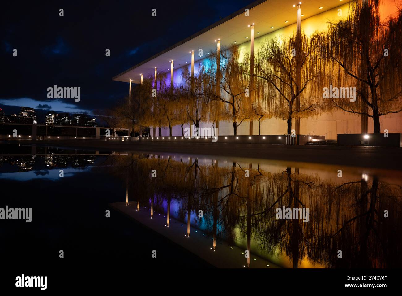 Kennedy Center à Washington DC // WASHINGTON DC — le John F. Kennedy Center for the Performing Arts est illuminé la nuit avec des lumières colorées pour le Kennedy Center Honors, son reflet capturé dans une flaque après une pluie récente. Le monument culturel emblématique sur le fleuve Potomac met en valeur sa beauté architecturale et son importance en tant que lieu national pour les art. Banque D'Images Kennedy Center à Washington DC // WASHINGTON DC — le John F. Kennedy Center for the Performing Arts est illuminé la nuit avec des lumières colorées pour le Kennedy Center Honors, son reflet capturé dans une flaque après une pluie récente. Le monument culturel emblématique sur le fleuve Potomac met en valeur sa beauté architecturale et son importance en tant que lieu national pour les art. Banque D'Images