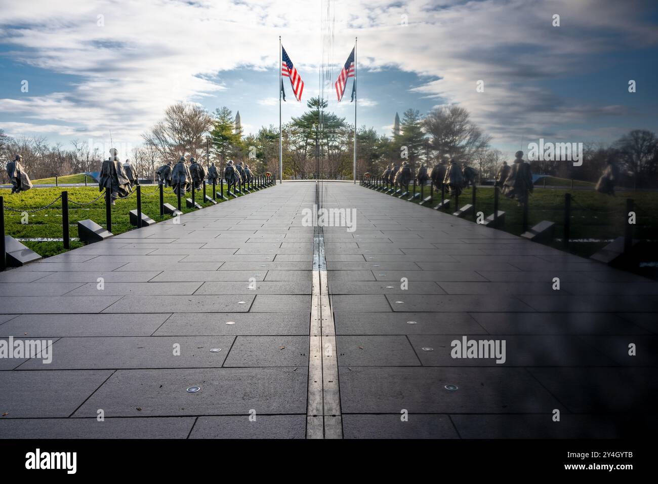 Memorial des anciens combattants de la guerre de Corée Reflections Washington DC // WASHINGTON DC — le Memorial des anciens combattants de la guerre de Corée présente des reflets spectaculaires de ses soldats en acier inoxydable contre le mur de granit noir. Situé sur le National Mall, le mémorial crée un effet visuel convaincant qui double le nombre apparent de soldats de 19 à 38. La surface réfléchissante sert à la fois à des fins artistiques et symboliques en honorant les anciens combattants de la guerre de Corée. Banque D'Images