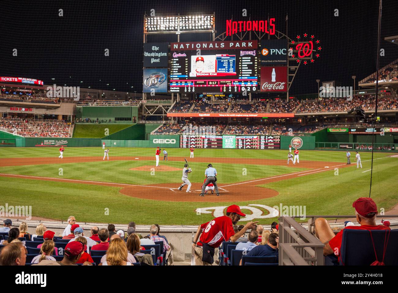 Nationals Park Baseball Game Washington DC // WASHINGTON DC — Une vue depuis les tribunes derrière la plaque de la maison lors d'un match de baseball nocturne au Nationals Park entre les Nationals de Washington et les Cardinals Louis. Les lumières du stade éclairent le terrain tandis que les fans regardent l'action de la MLB sous le ciel nocturne. Banque D'Images