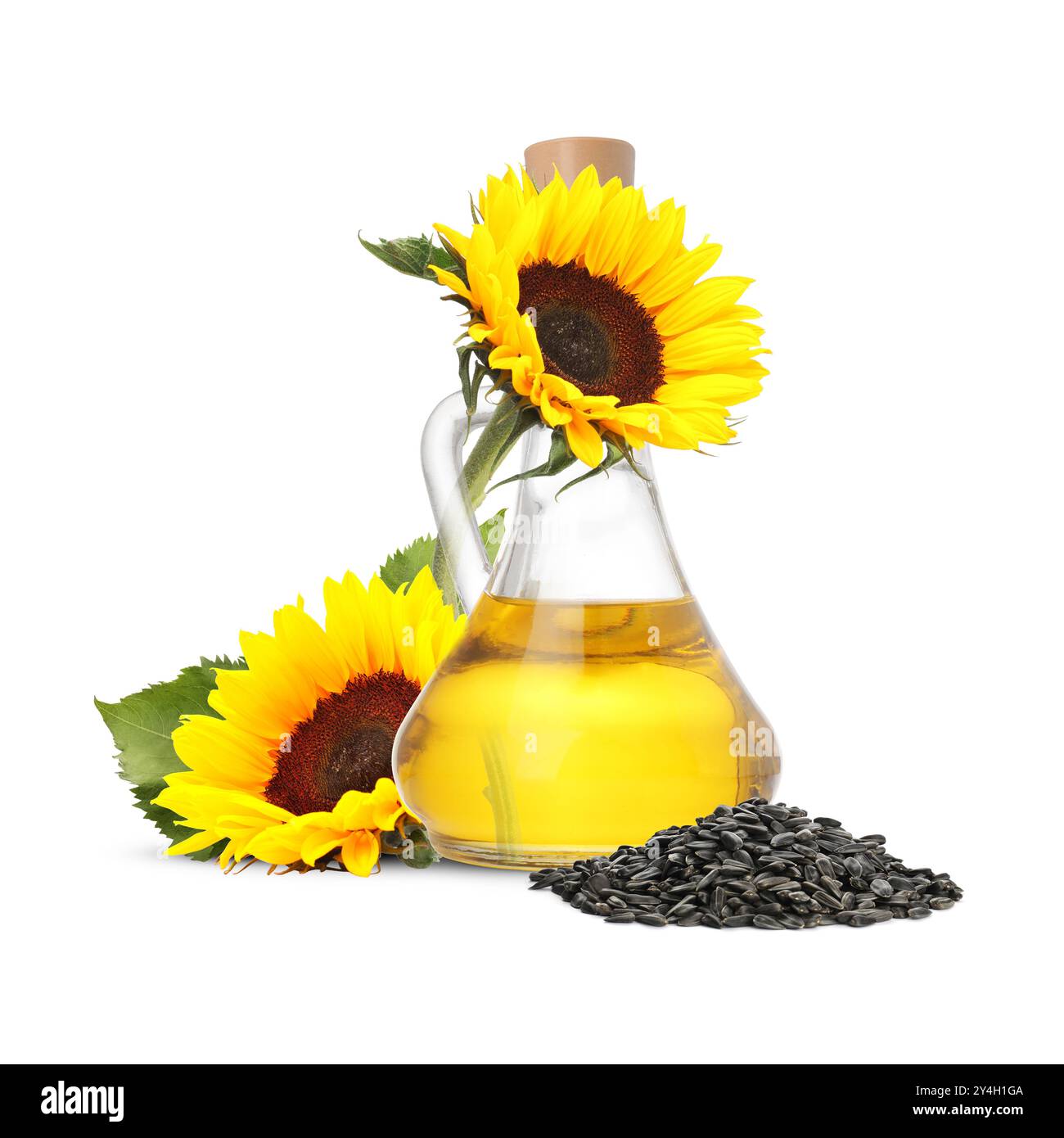 Huile de cuisson dans une cruche en verre, graines de tournesol et fleurs isolées sur blanc Banque D'Images