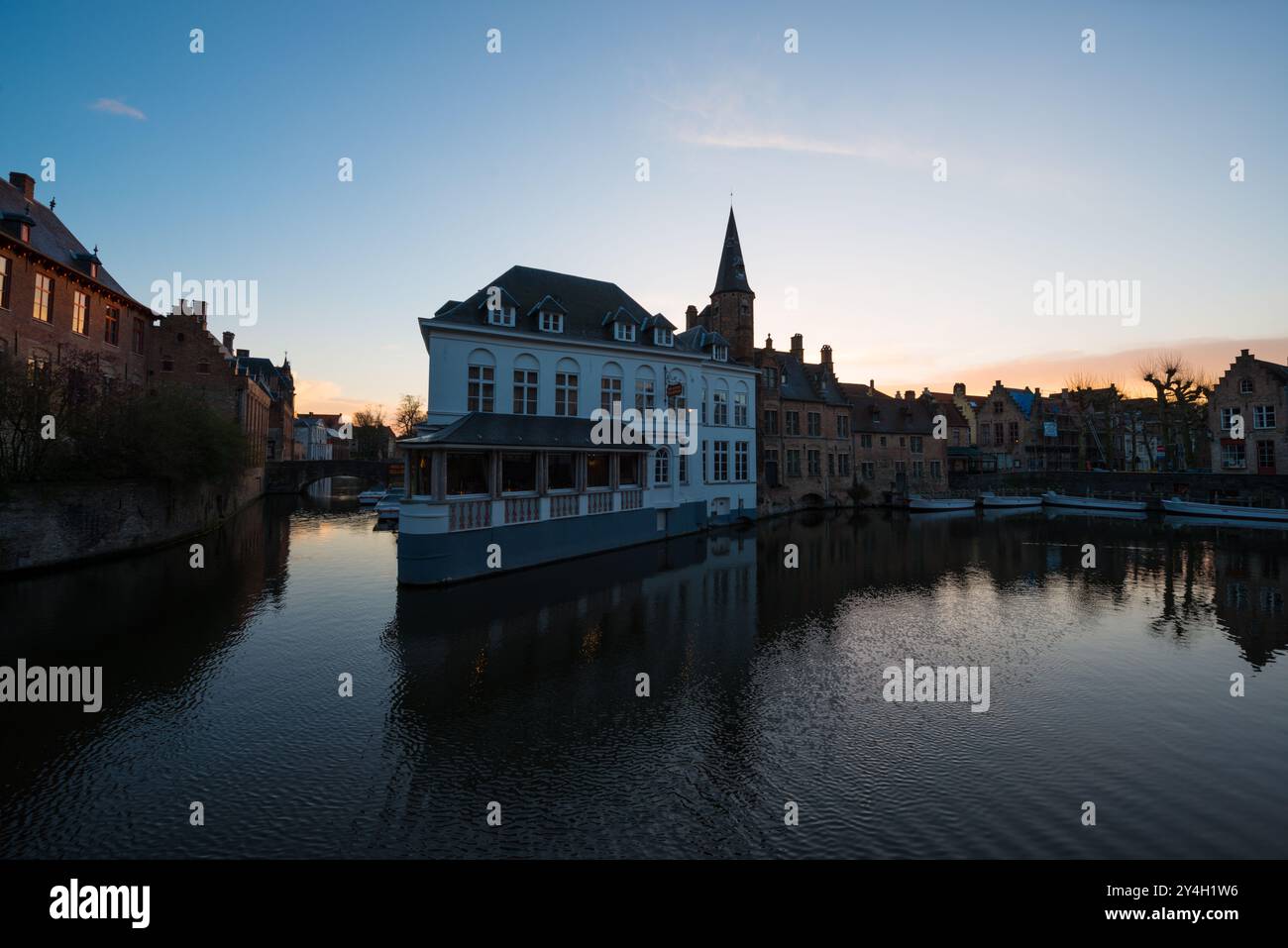 BRUGES, Belgique — les canaux médiévaux de Bruges mettent en valeur le réseau historique de voies navigables de la ville, bordés d'une architecture gothique bien préservée. Ces voies navigables pittoresques, qui ont valu à Bruges le surnom de « Venise du Nord », reflètent des siècles de commerce maritime et de développement urbain. Le système de canaux reste au centre du patrimoine mondial de l'UNESCO de la ville. Banque D'Images