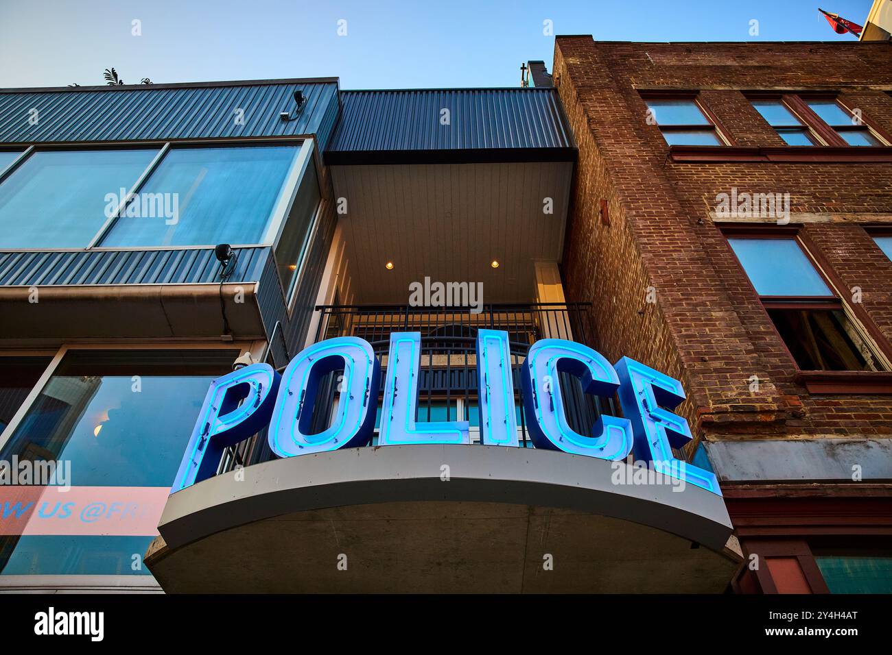 Panneau de police au néon sur le bâtiment à architecture mixte vue à angle bas Banque D'Images