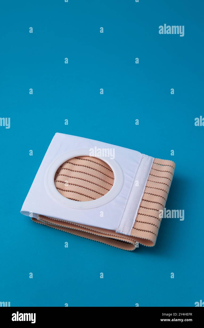 ceinture abdominale pliée avec ouverture de stomie pour les patients de colostomie sur fond bleu Banque D'Images ceinture abdominale pliée avec ouverture de stomie pour les patients de colostomie sur fond bleu Banque D'Images