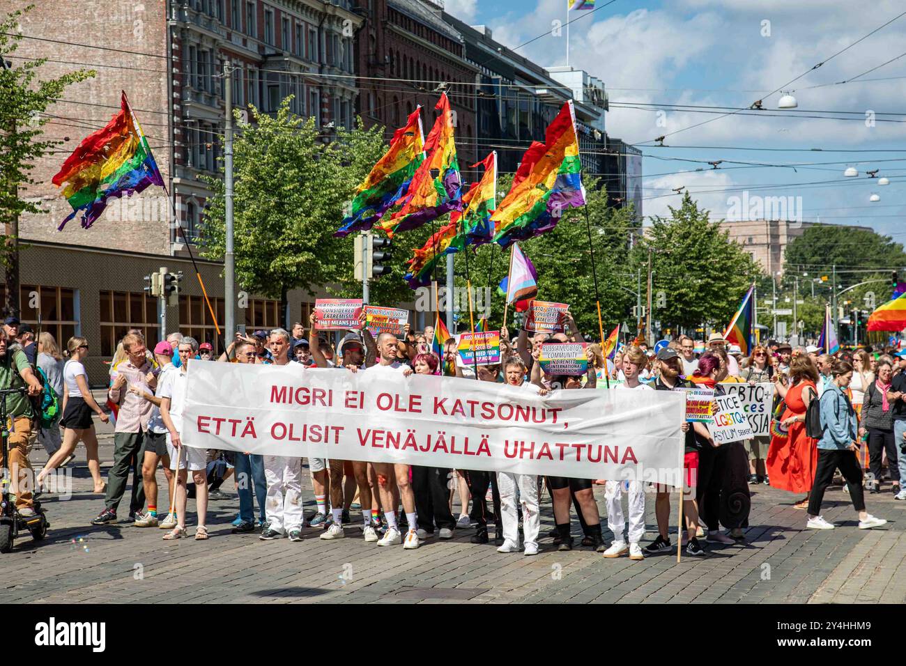 Demandeurs d'asile LGBT russes avec une bannière et des drapeaux arc-en-ciel déchirés lors du défilé de la fierté Helsinki 2024 sur Mannerheimintie à Helsinki, en Finlande Banque D'Images