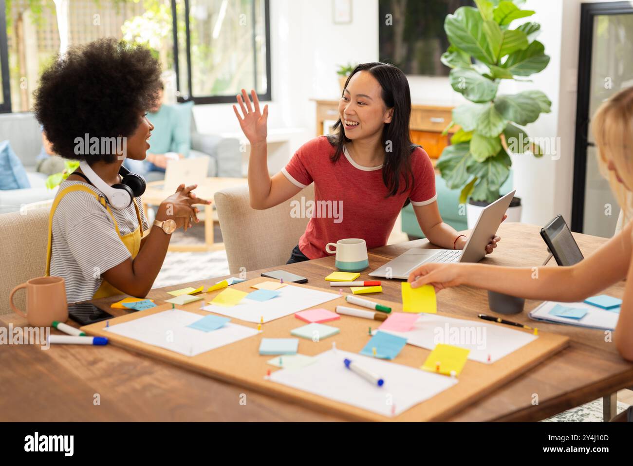 Collaboration sur le projet, brainstorming entre amis avec des notes adhésives et un ordinateur portable, démarrage d'entreprise Banque D'Images