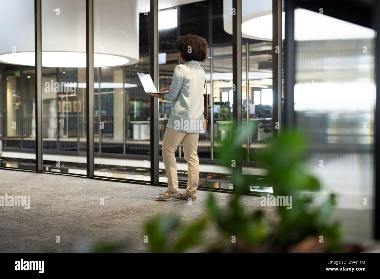 Marcher dans le bureau, femme utilisant un ordinateur portable pour le travail, en se concentrant sur la tâche Banque D'Images