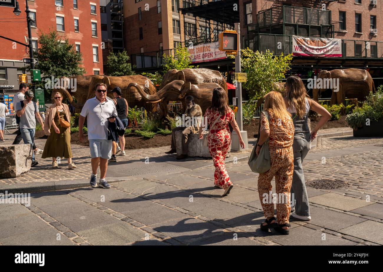 Les gens sont impressionnés par l’installation d’art public Great Elephant migration dans le Meatpacking District de New York le jeudi 5 septembre 2024. Les 100 statues ont été créées par le collectif coexistence dont la mission aide les gens à partager l'espace avec des créatures magnifiques. Les éléphants ont été construits par des artisans indigènes indiens à partir du Lantana Camara, une espèce végétale envahissante. L'installation sera exposée jusqu'au 20 octobre. (©ÊRichard B. Levine) Banque D'Images