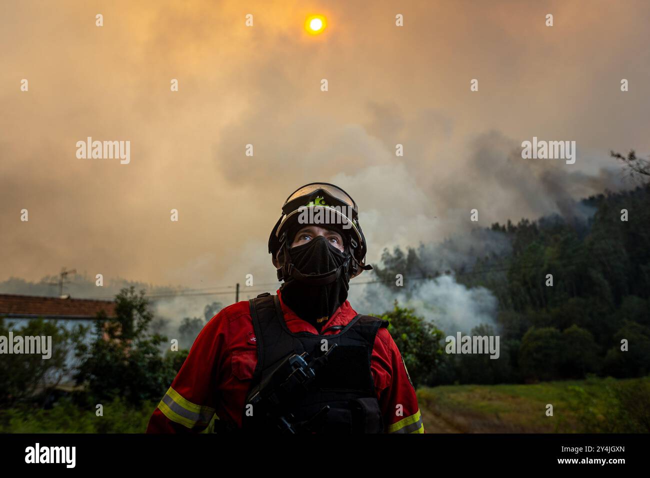 Un pompier est vu en action à Ribeira de Fráguas tandis que le feu de forêt approche du village. Le premier ministre a annoncé, ce mardi, l'élévation à l'état de calamité dans toutes les municipalités touchées par les incendies. Banque D'Images