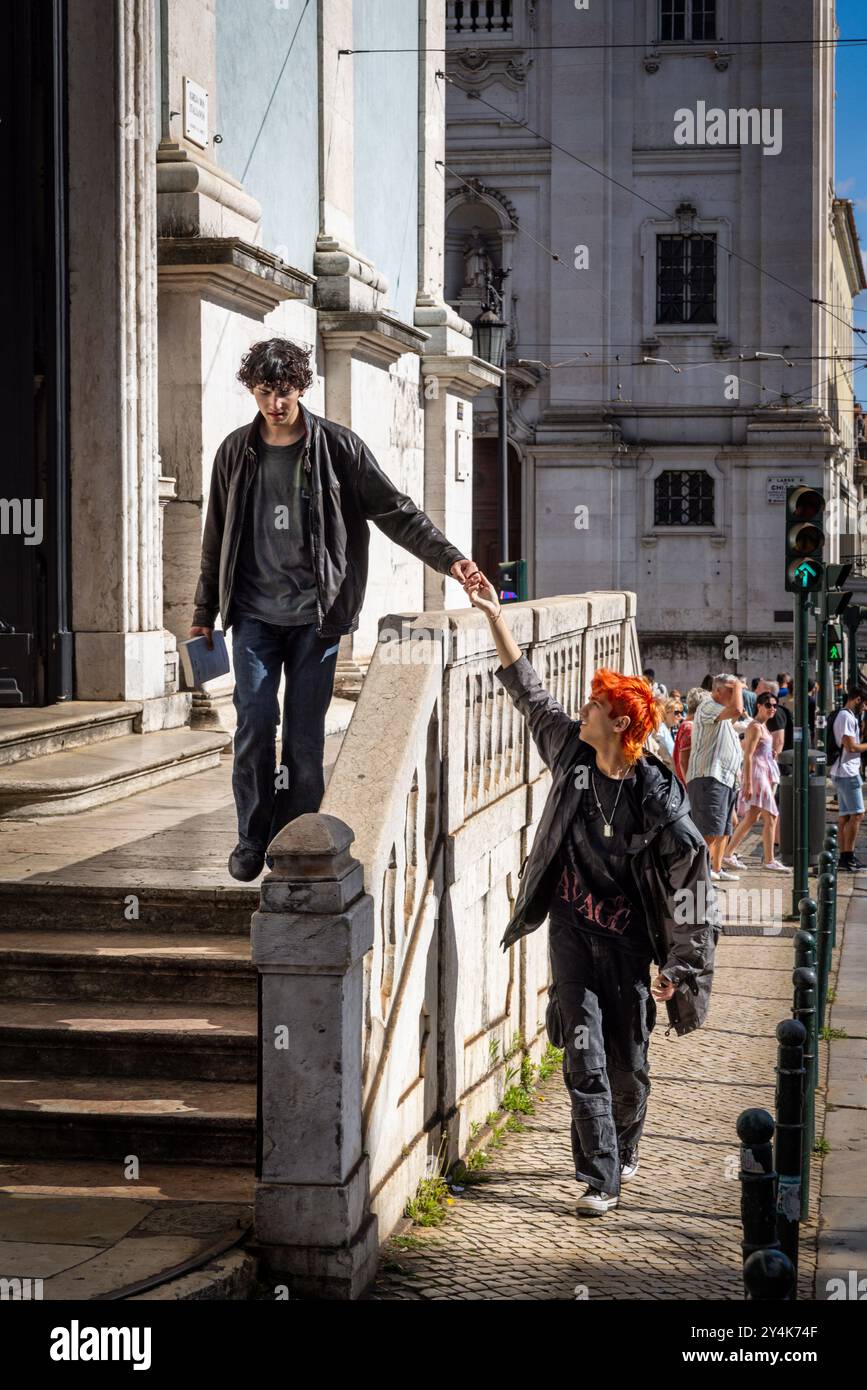 Deux jeunes hommes marchant dans une rue se tenant la main à Lisbonne, Portugal Banque D'Images