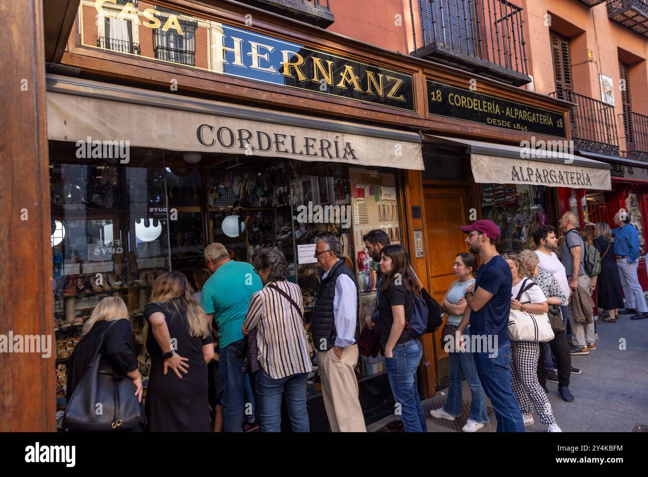 Une longue file de clients attendent pour entrer Casa Hernanz à Madrid, Espagne. Banque D'Images