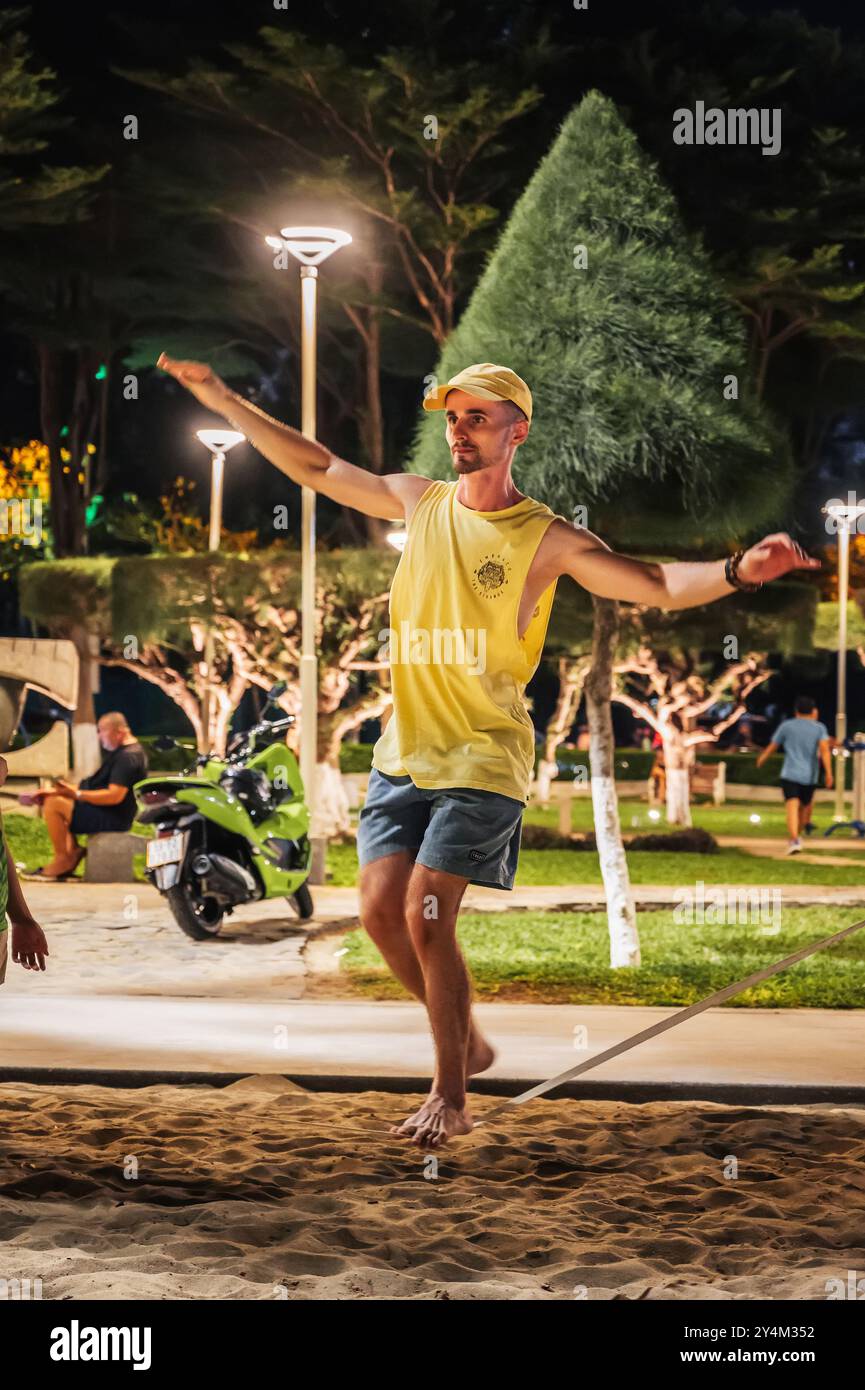 acrobate mâle marche sur une corde et s'entraîne slackline sur la plage. Nha Trang, Vietnam - 25 juillet 2024 Banque D'Images