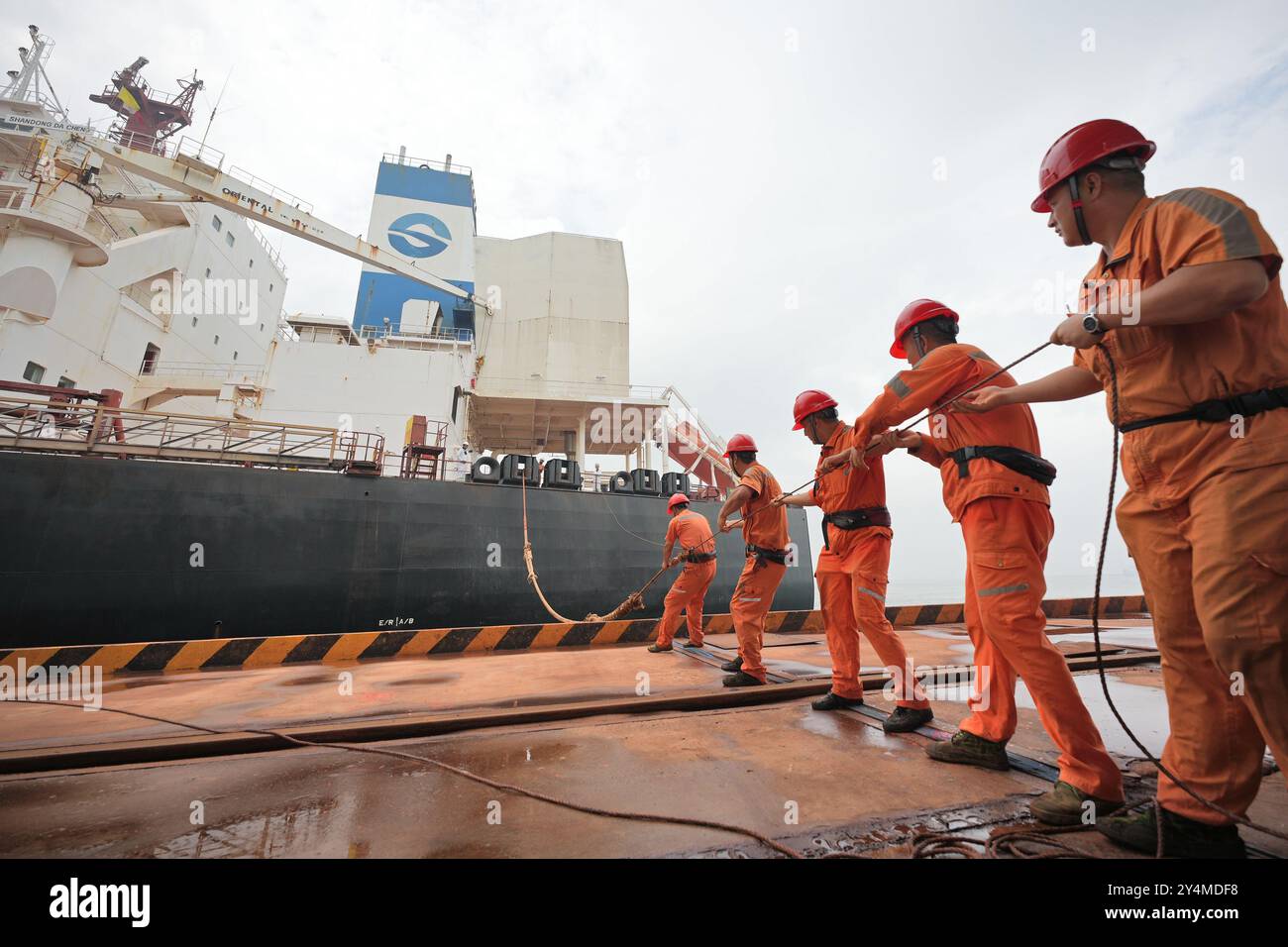 YANTAI, CHINE - 19 SEPTEMBRE 2024 - des travailleurs des quais amarrent un câble pour un transporteur de minerai de très grande taille de 400 000 tonnes à Yantai, dans la province du Shandong, en Chine, le 19 septembre Banque D'Images