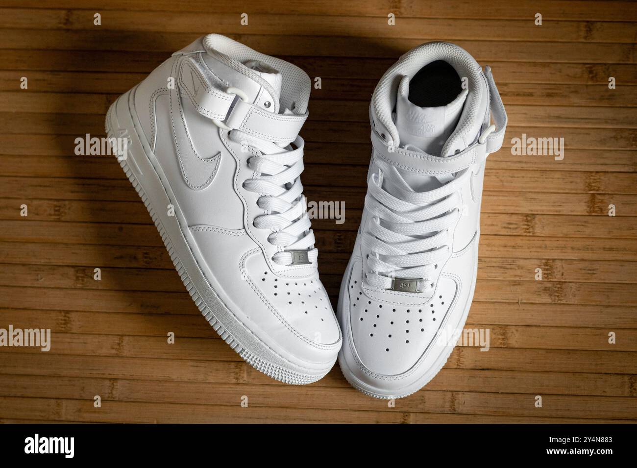 Toute nouvelle paire de baskets nike air force One MID blanches repose sur un plancher en bois Banque D'Images