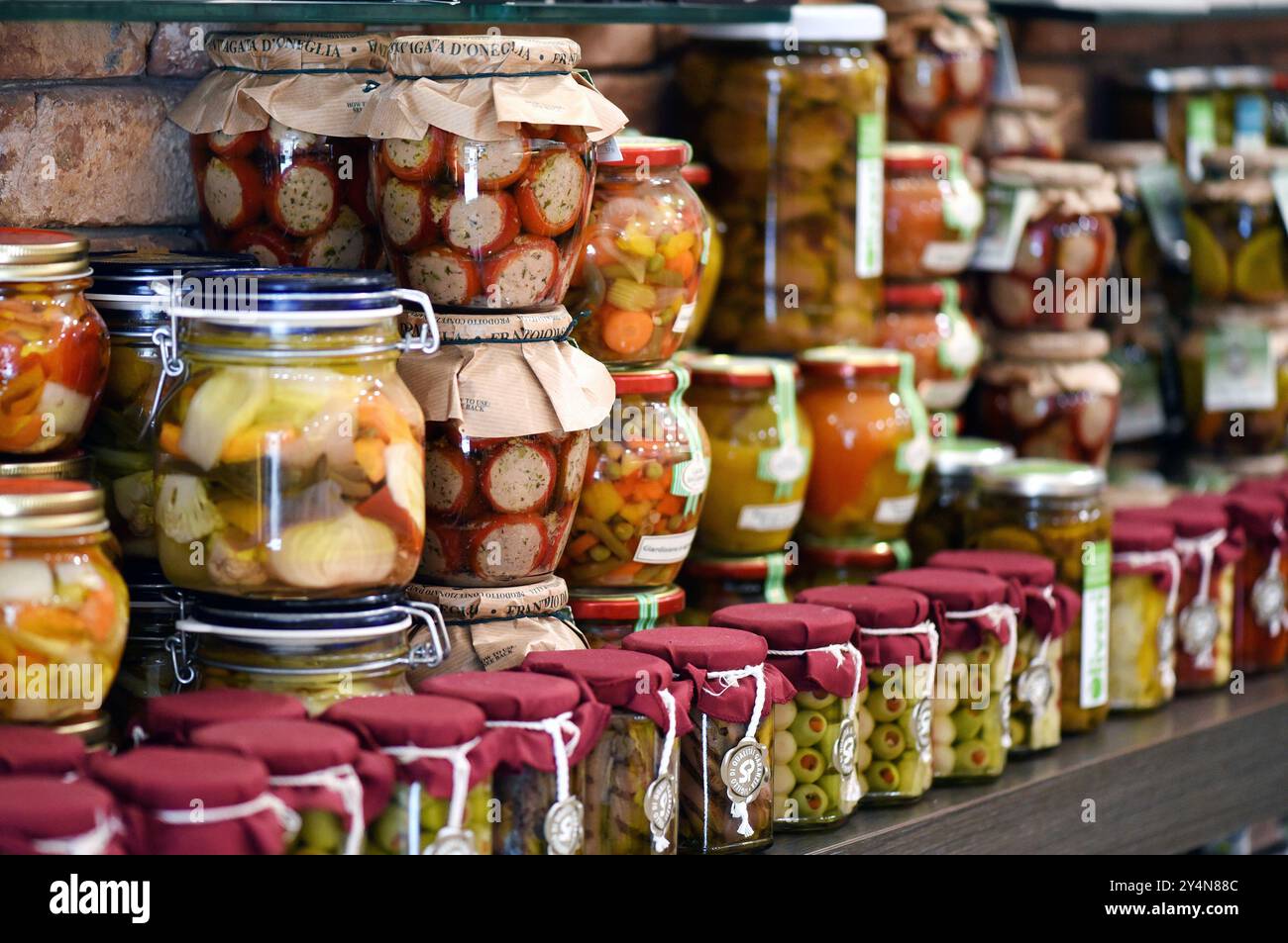 Variété de bocaux en verre remplis de légumes conservés colorés affichés sur une étagère dans une épicerie Banque D'Images