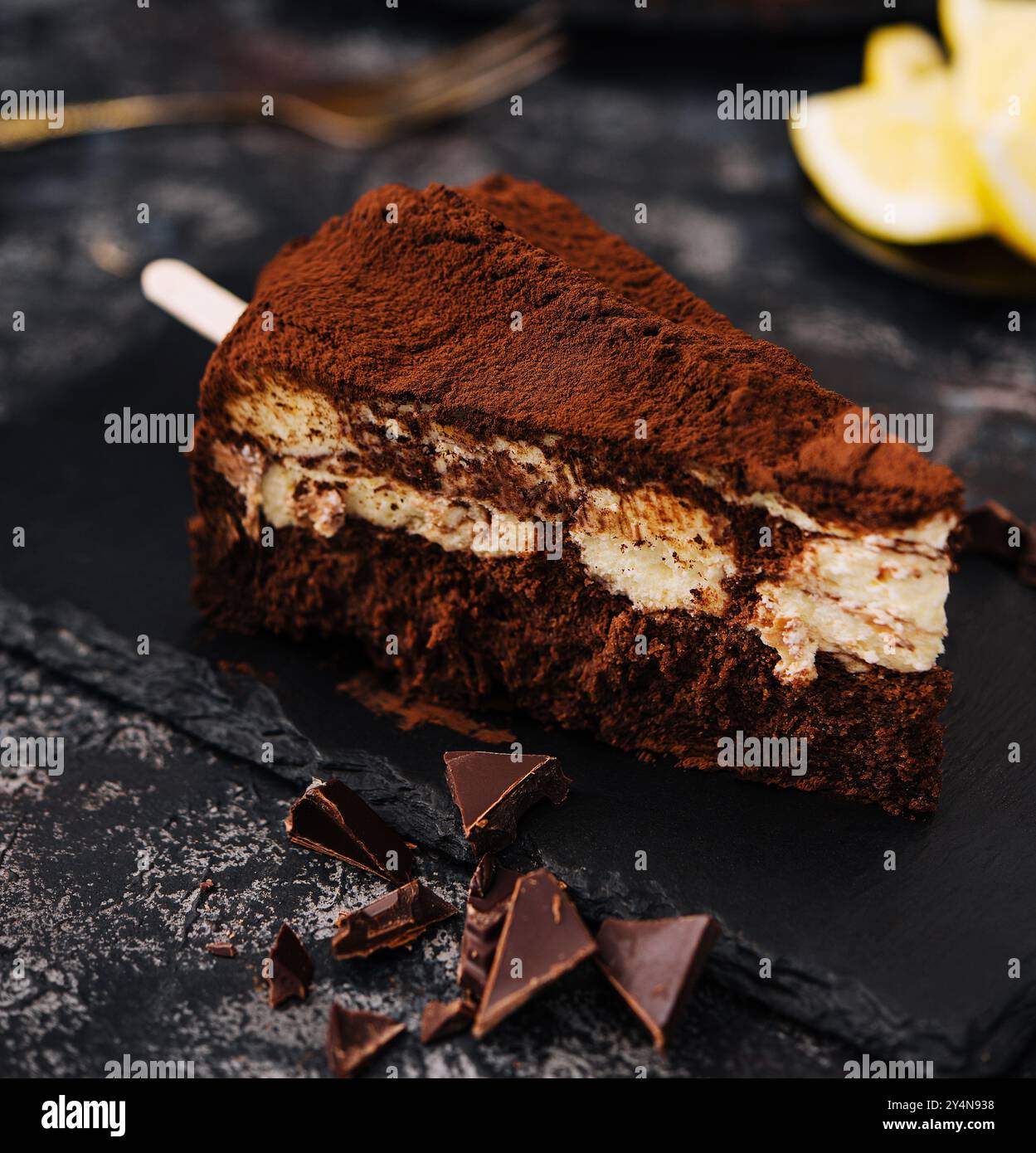 Composition avec tiramisu, tranches de chocolat sur tableau noir Banque D'Images