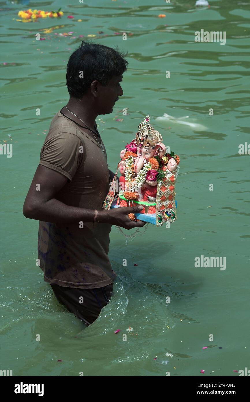 Vadodara, Gujarat / Inde - 15 septembre 2016 : Un homme dissout la statue du Seigneur Shree Ganesha dans l'eau du lac de Sursagar lors de la fête de Ganesha Banque D'Images