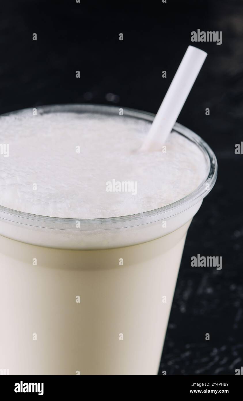milkshake dans une tasse en plastique sur fond noir Banque D'Images