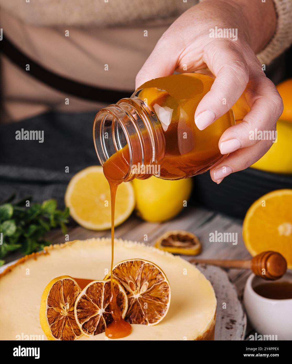 femme versant du caramel sur le cheesecake à l'orange Banque D'Images