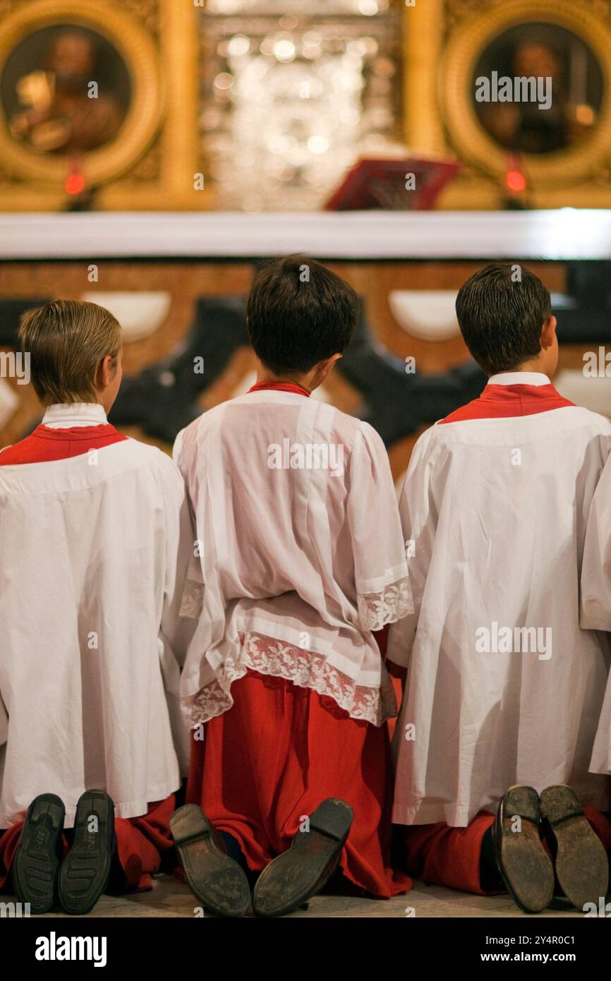 Les garçons de l'autel s'agenouillent en prière à la fin de la procession du Corpus Christi dans l'église du Sagrario, à Séville, pendant un moment solennel en 2009. Banque D'Images