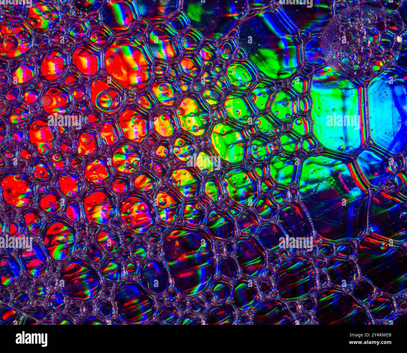 Une photo macro montrant des motifs et des couleurs de gouttes d'huile flottant sur l'eau Banque D'Images