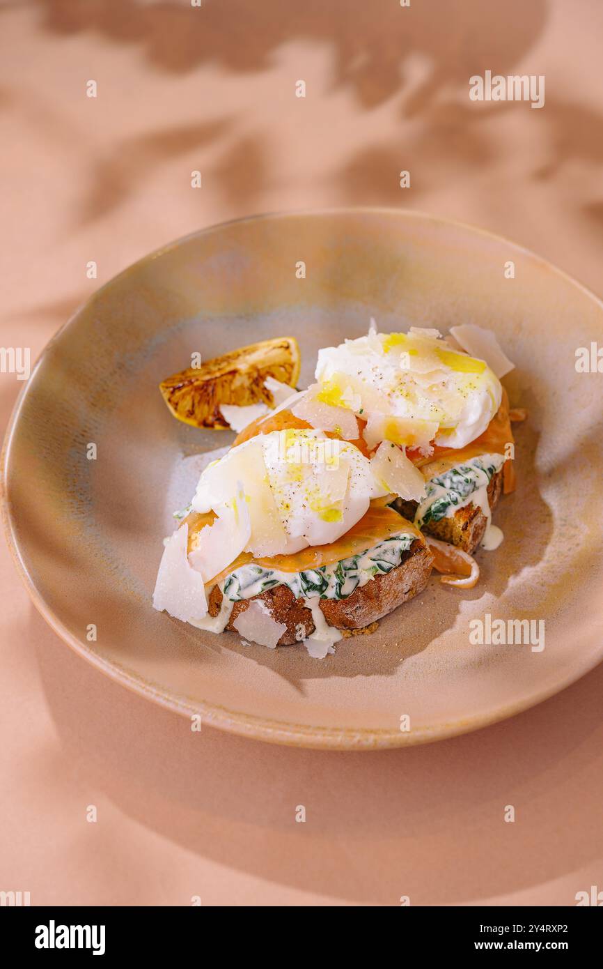 Plat de brunch élégant composé d'œufs pochés sur un toast infusé d'herbes, garni d'épices Banque D'Images