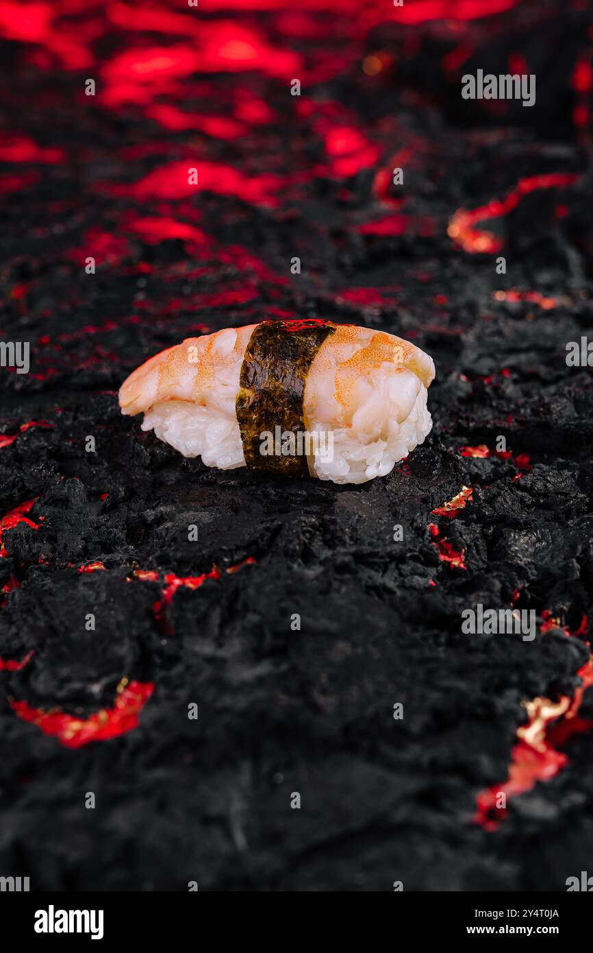 Des sushis gastronomiques exquis servis sur une roche volcanique grésillante. Mettant en valeur l'élégante fusion de la cuisine japonaise traditionnelle avec une touche moderne Banque D'Images
