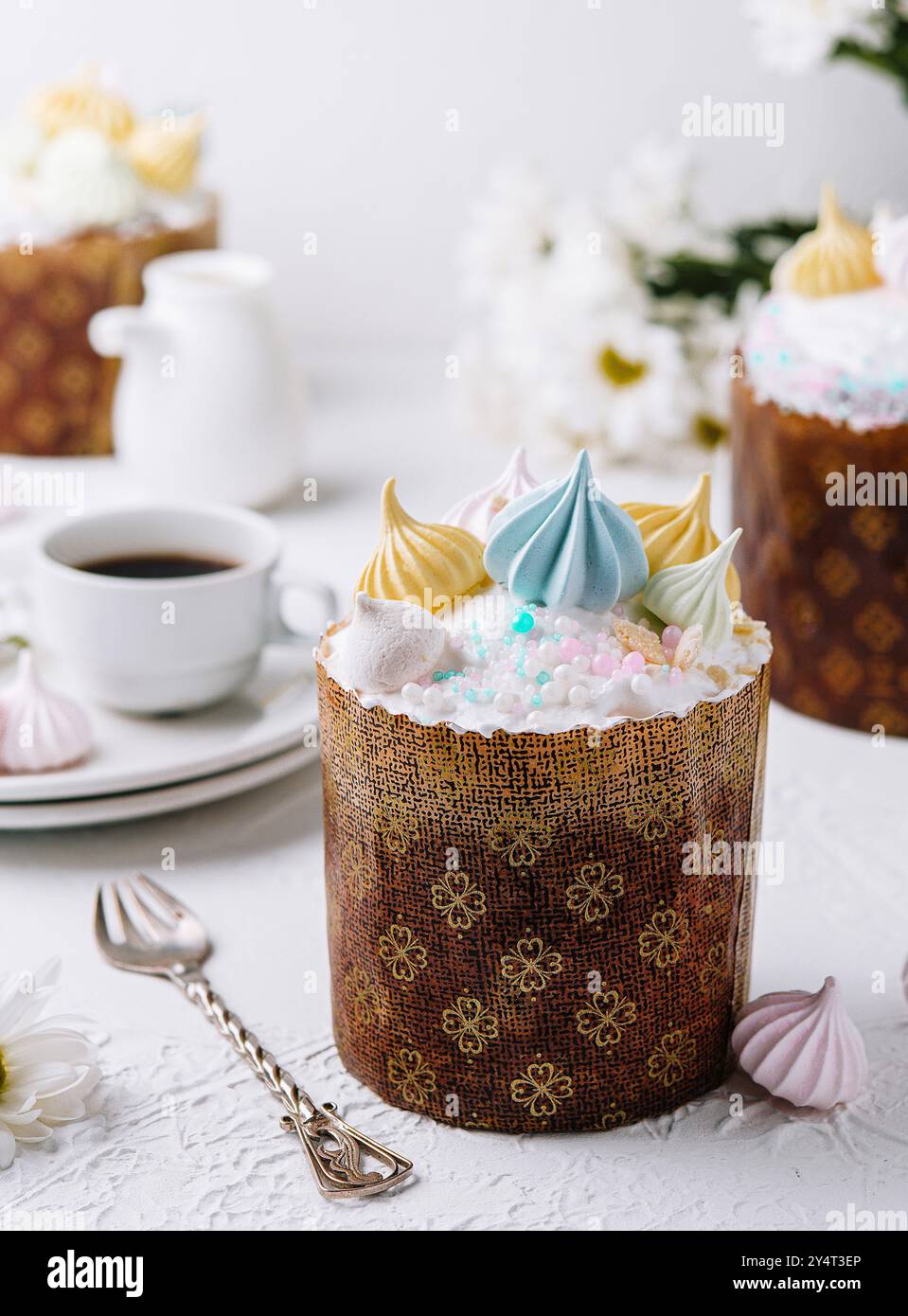 Kulich traditionnel de pâques garni de glaçage pastel et de merengues, servi avec du thé Banque D'Images