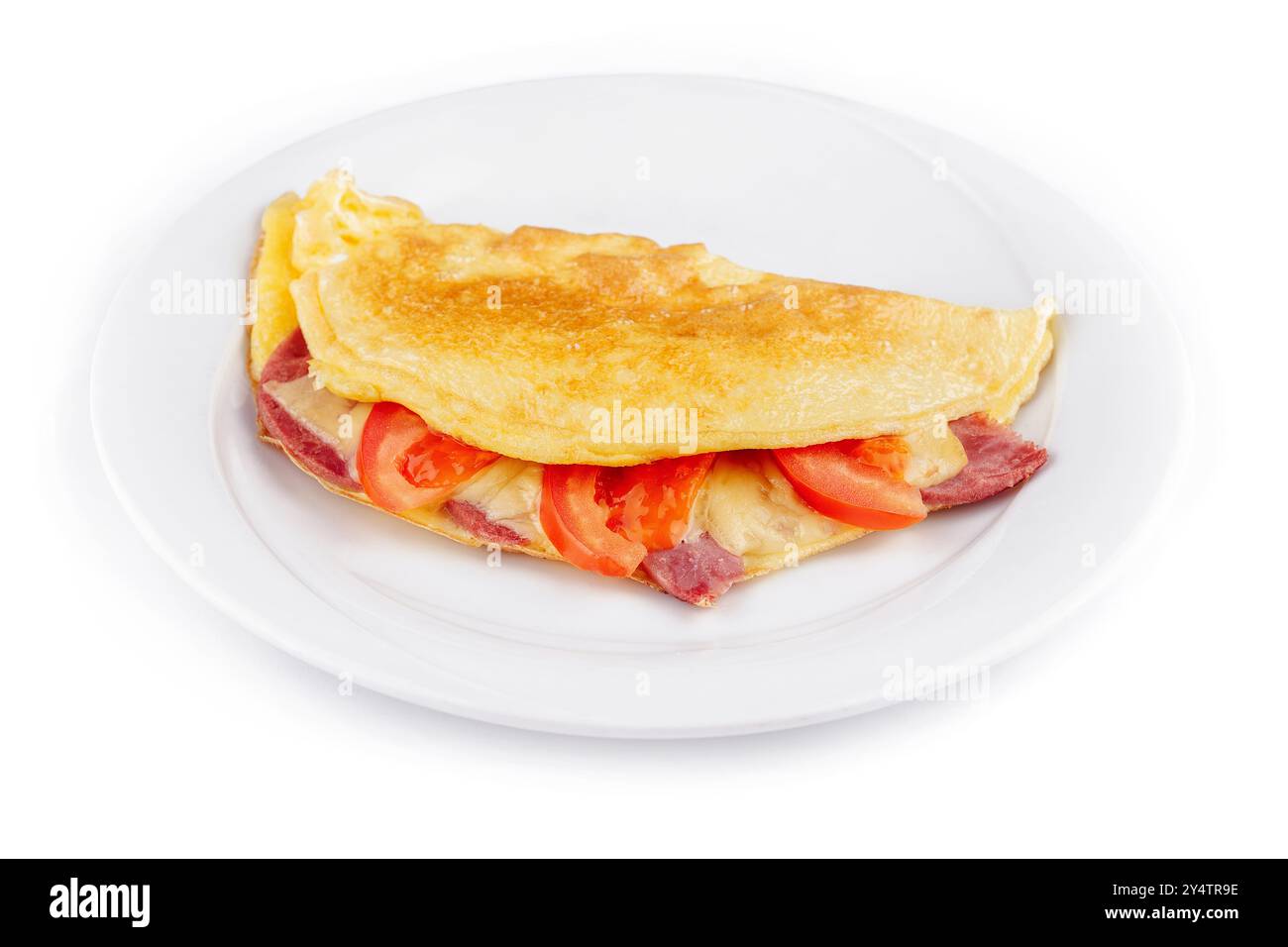 Délicieuse omelette pliée fourrée de fromage, jambon et tomates, servie sur une assiette blanche, isolée sur fond blanc Banque D'Images