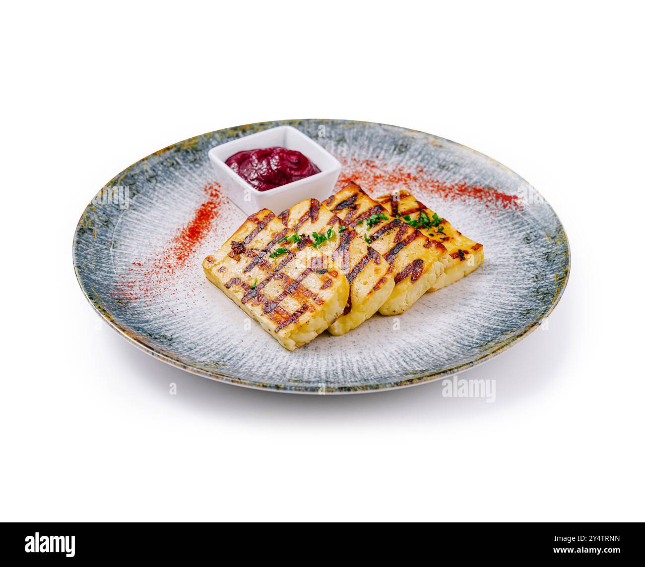 Tranches de fromage halloumi, grillées à la perfection et servies avec une sauce aux baies vibrante sur une assiette élégante Banque D'Images
