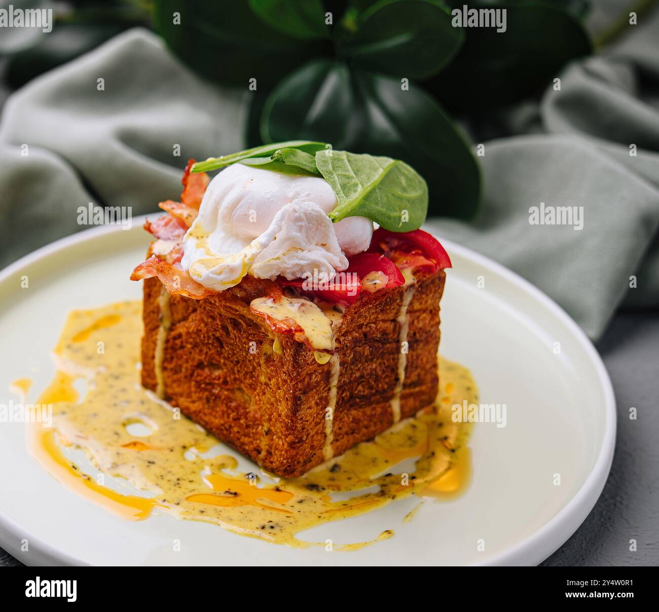 Touche moderne sur les œufs benoît avec œuf poché et sauce hollandaise sur un cube brioche Banque D'Images