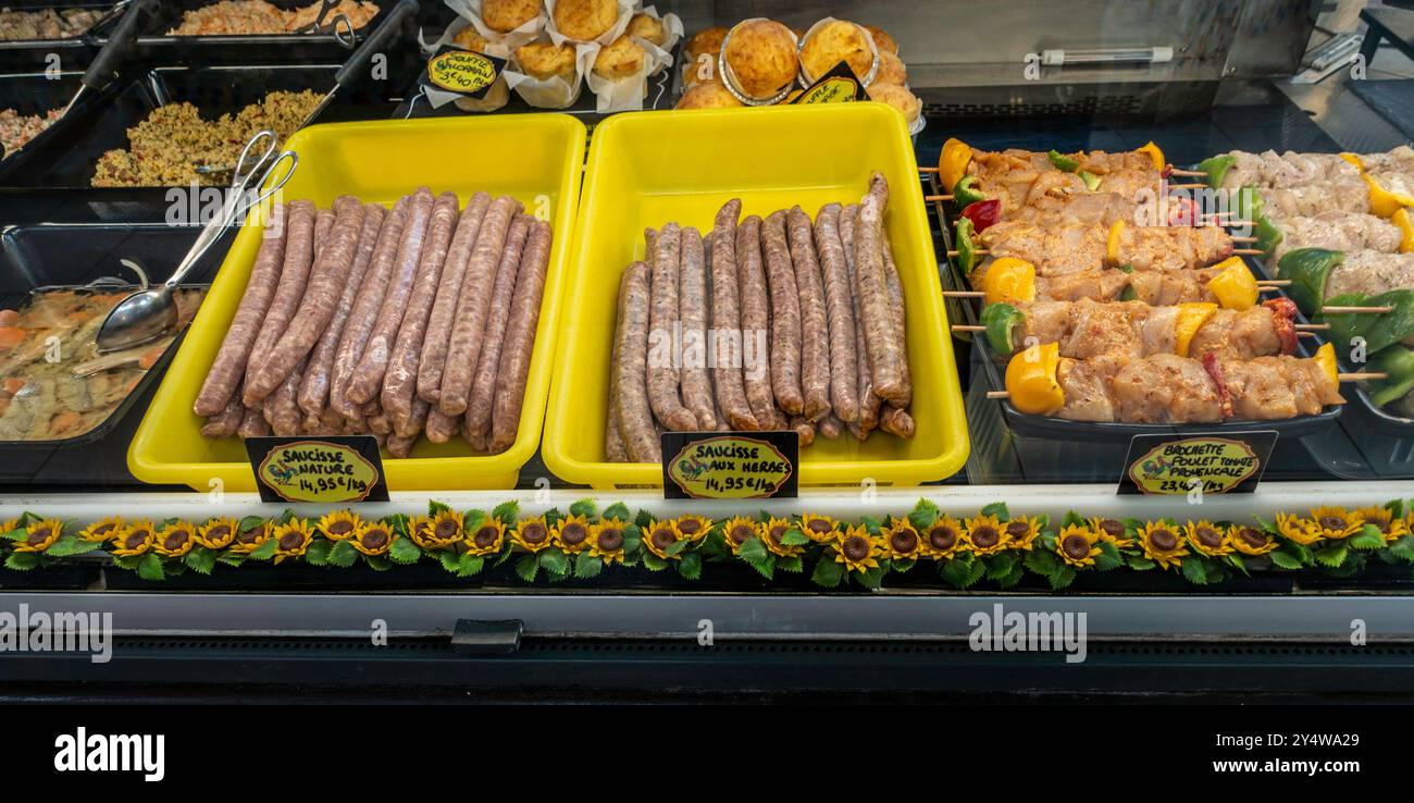 Saucisse et saucisse aux herbes, brochettes de poulet marinées en vente sur un étal de marché à Arcachon, France. Banque D'Images