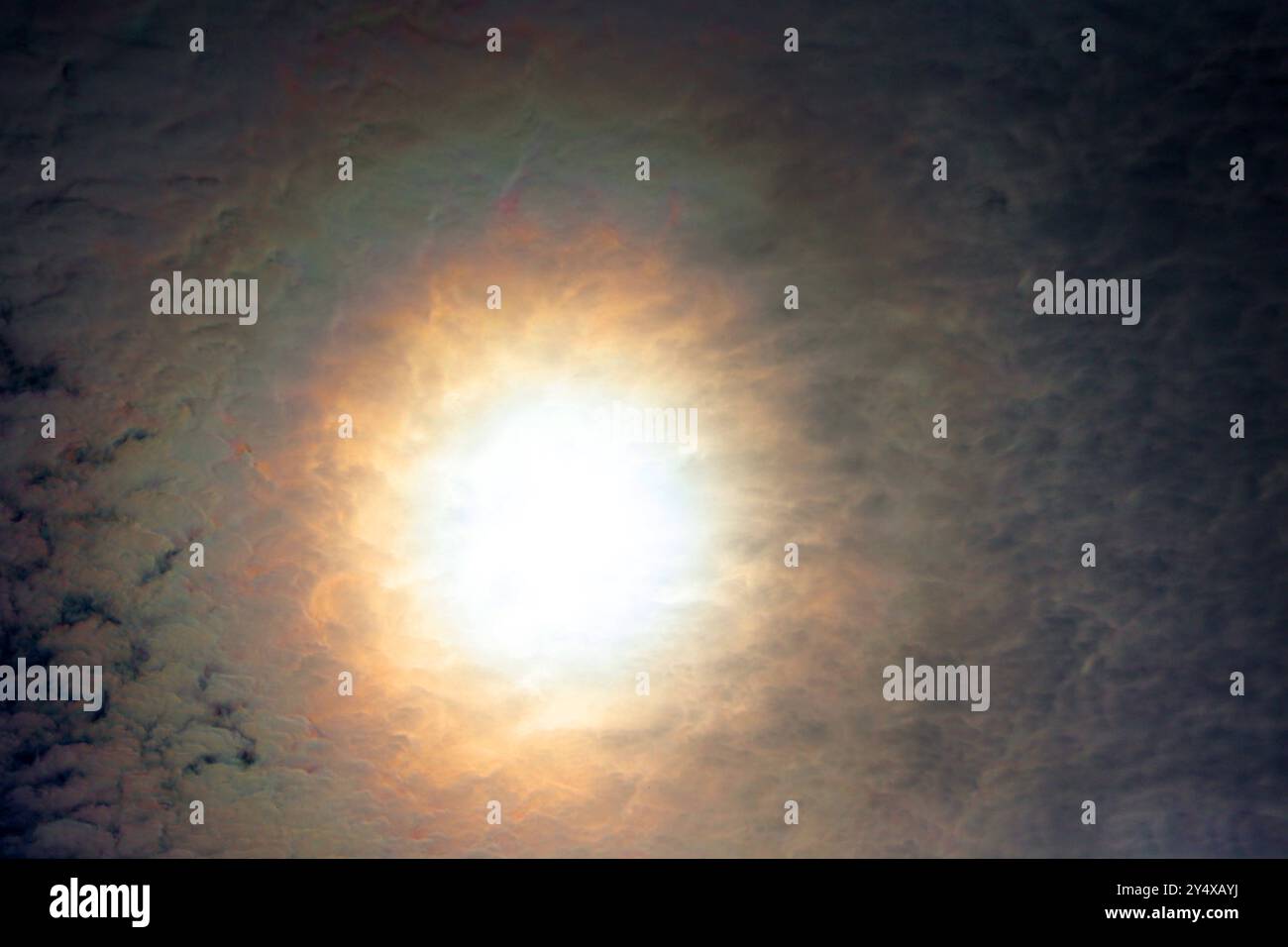 Lichtbeugung am Himmel Ein Hof, auch bekannt als Korona am Himmel bildet farbige Leuchterscheinungen um die sonne herum, die durch Beugung des Lichts an den Wassertropfen der Wolken entstehen. *** Diffraction de la lumière dans le ciel Un halo, également connu sous le nom de couronne dans le ciel, forme des phénomènes lumineux colorés autour du soleil, qui sont créés par la diffraction de la lumière par les gouttelettes d'eau dans les nuages Banque D'Images