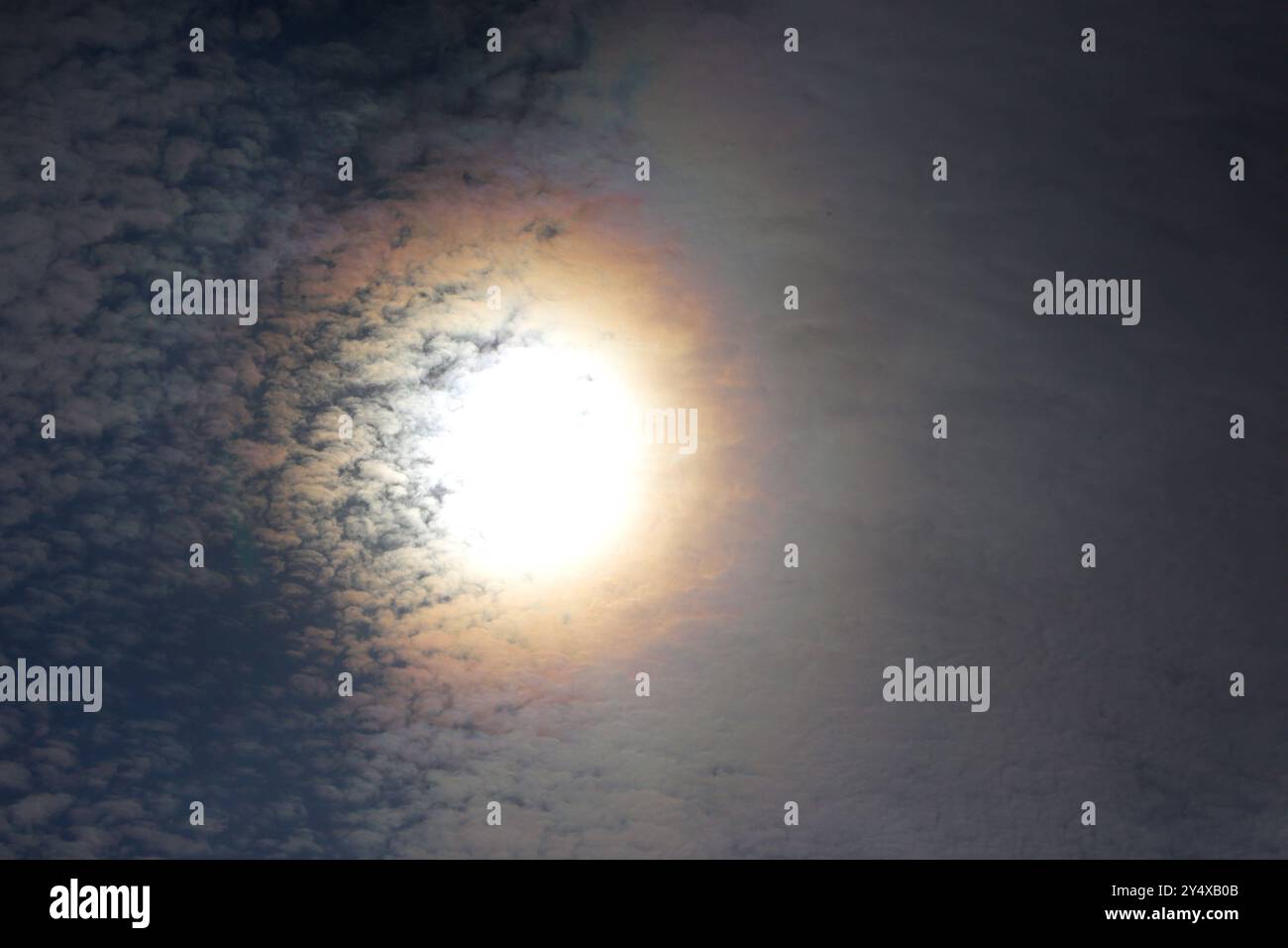 Lichtbeugung am Himmel Ein Hof, auch bekannt als Korona am Himmel bildet farbige Leuchterscheinungen um die sonne herum, die durch Beugung des Lichts an den Wassertropfen der Wolken entstehen. *** Diffraction de la lumière dans le ciel Un halo, également connu sous le nom de couronne dans le ciel, forme des phénomènes lumineux colorés autour du soleil, qui sont créés par la diffraction de la lumière par les gouttelettes d'eau dans les nuages Banque D'Images
