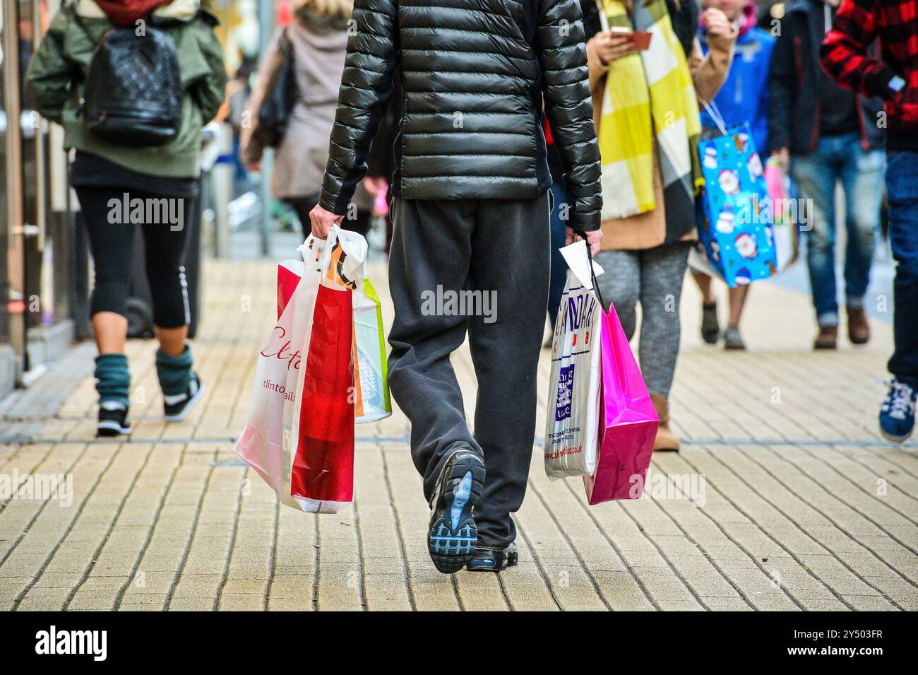 Photo du dossier datée du 24/12/2016 d'un homme transportant des sacs dans le quartier commercial Broadmead de Bristol. La confiance des consommateurs a fortement chuté en "peu encourageantes nouvelles" pour le gouvernement alors que les ménages attendent "nerveusement" le budget d'automne du mois prochain, selon une enquête de longue date. L'indice de confiance des consommateurs de GfK a chuté de sept points en septembre pour s'établir à moins 20, avec des baisses significatives des prévisions pour les finances personnelles et l'économie générale au cours de l'année à venir. Date d'émission : vendredi 20 septembre 2024. Banque D'Images